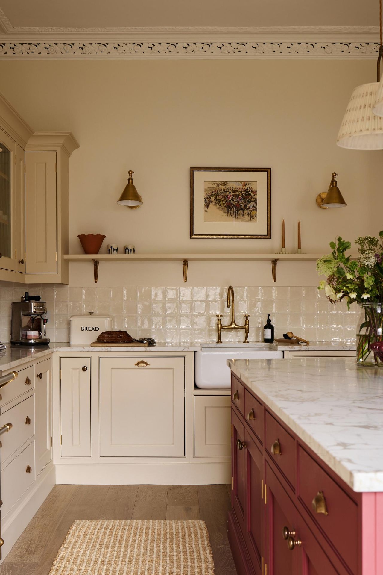 A white kitchen with a red island and glossy backsplash tiles