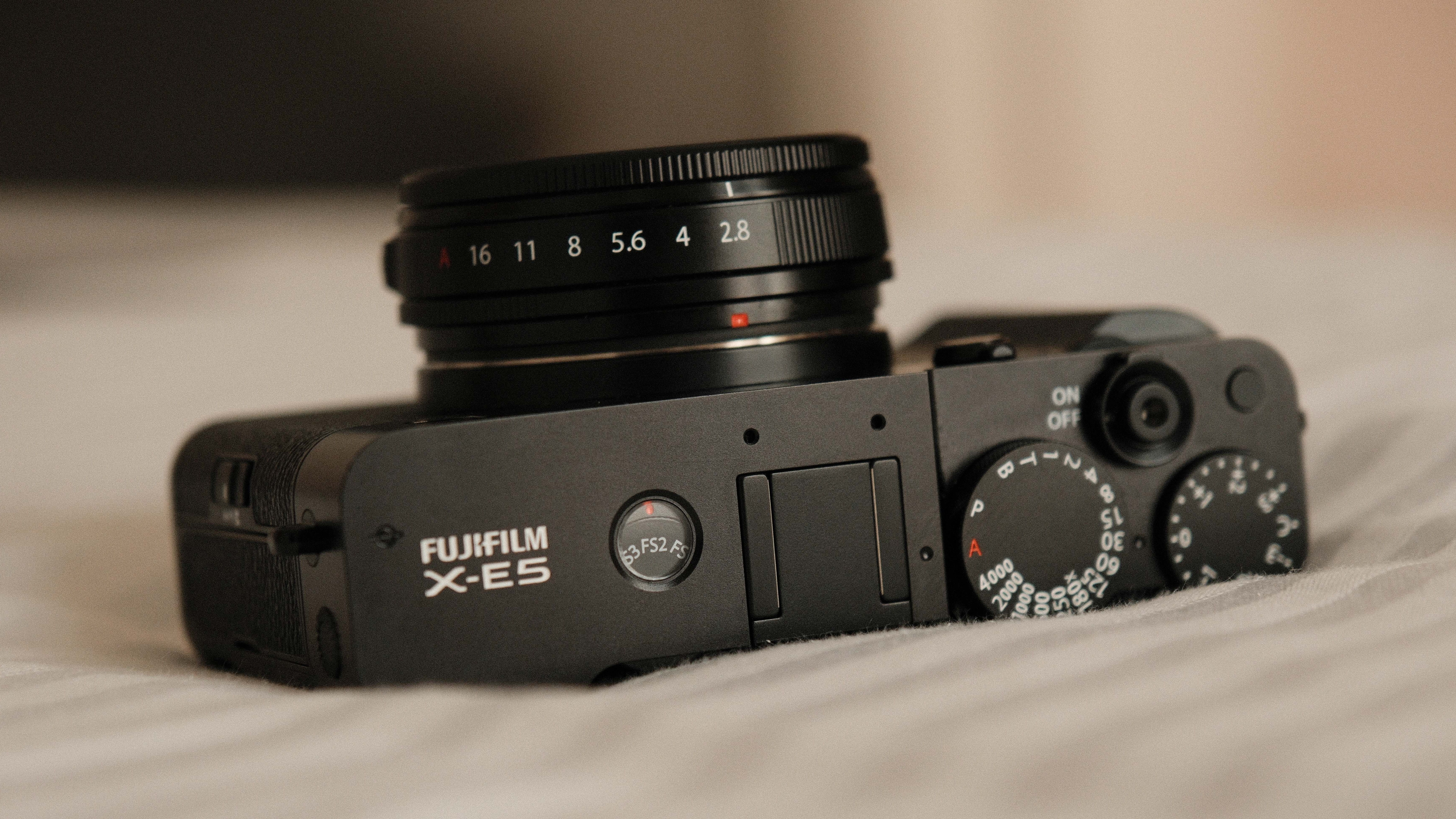 Fujifilm X-E5 camera with a 23mm f/2.8 R WR lens attached on a white bedspread