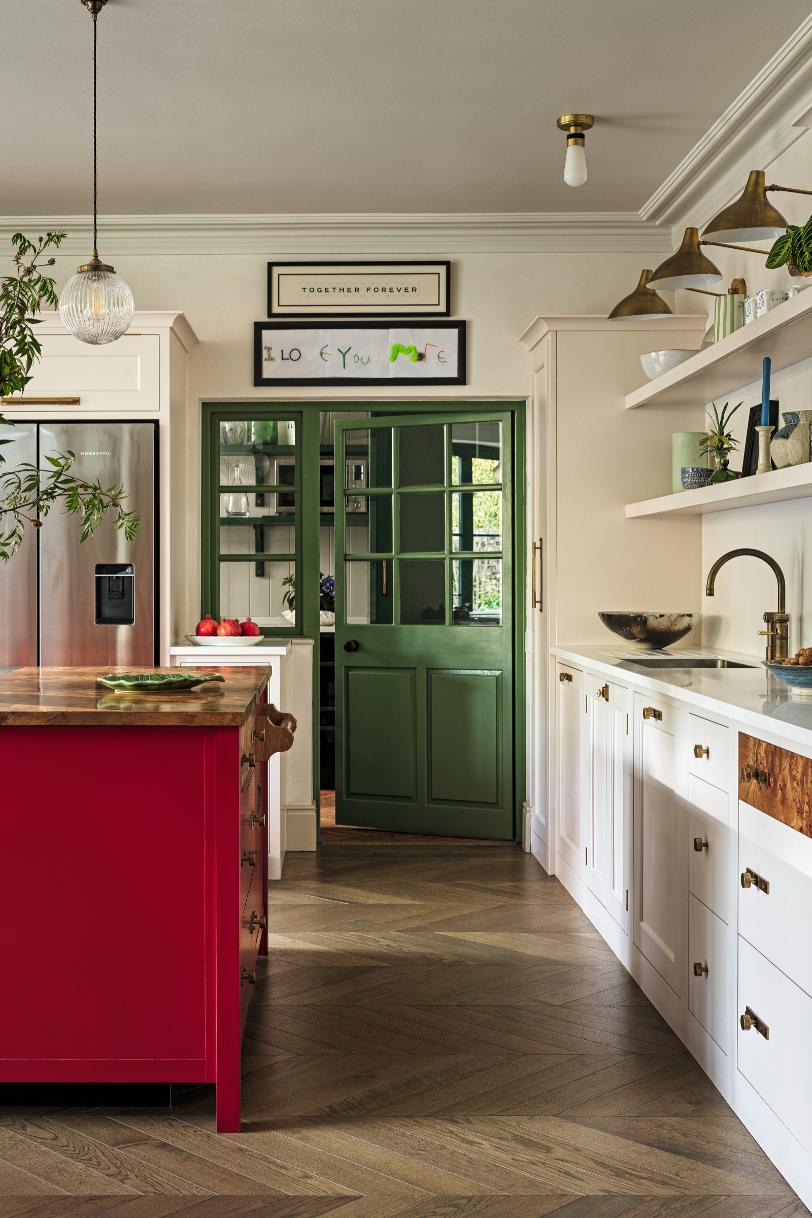 a kitchen with a red kitchen island, white cabinets, open shelves, and a green pantry door