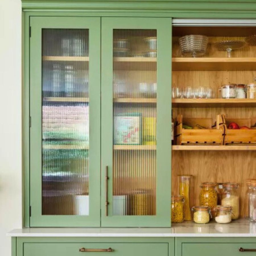 A small green pantry with a wooden back