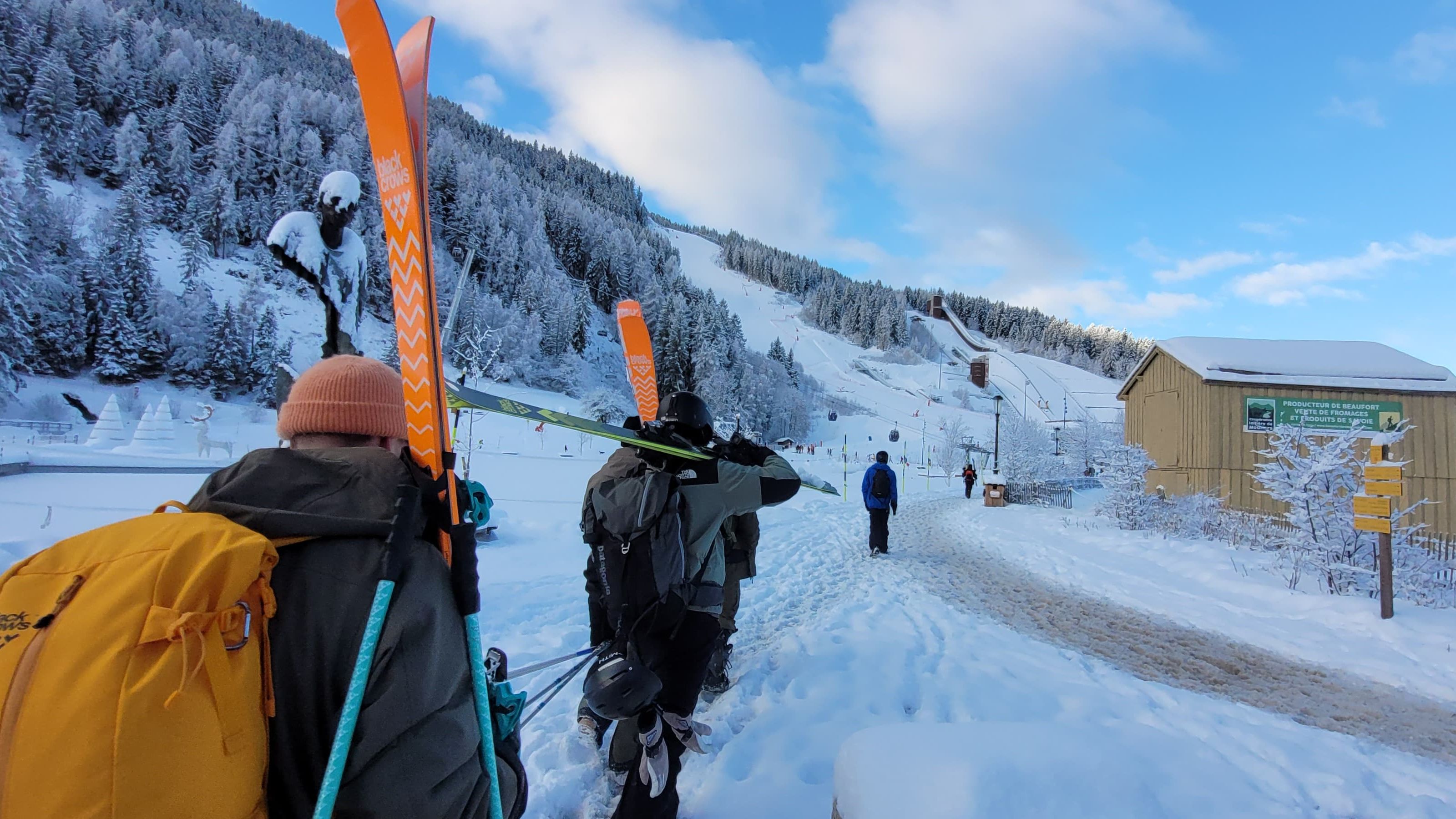an image of a group of friends walking down a path in a mountainside in courchevel