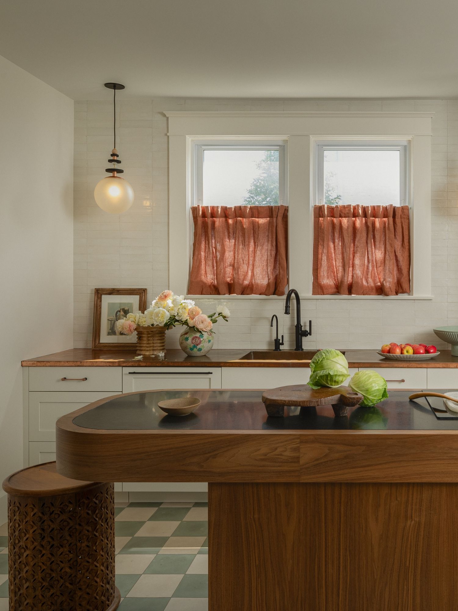 A small kitchen with white cabinets and aged metal countertops