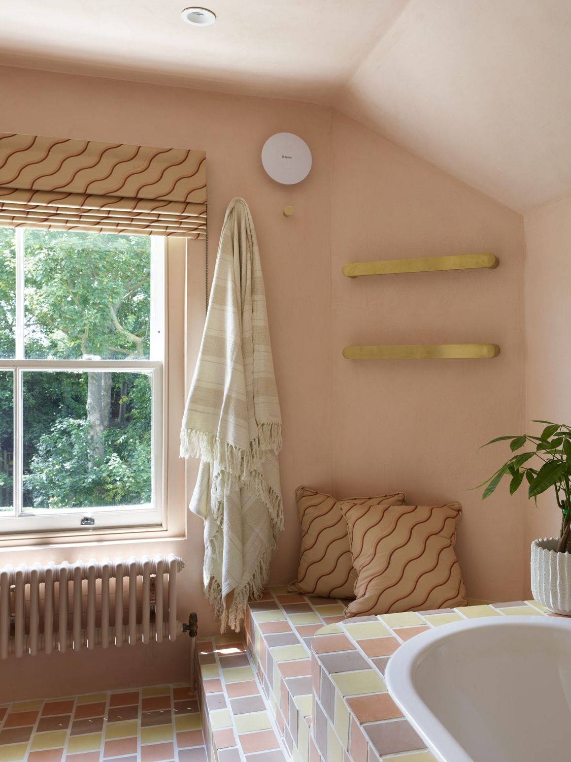 Pink-toned bathroom with plaster walls and sunken bath