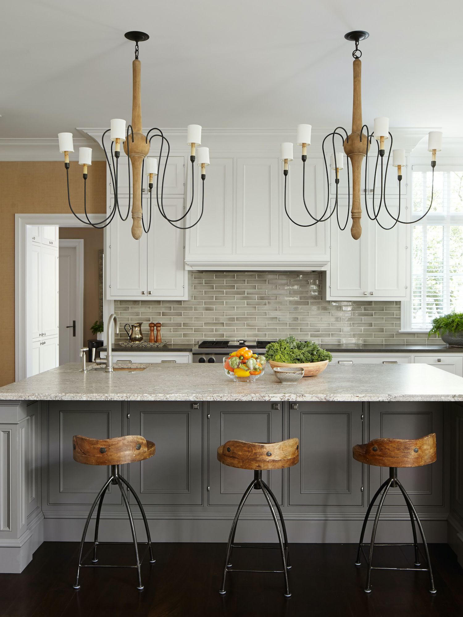 grey and white kitchen with large island and double chandeliers