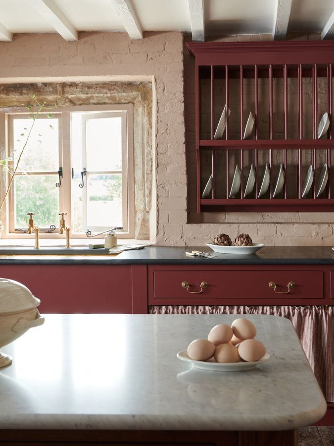 Cottage kitchen with beamed ceiling, burgundy cabinets and wall mounted dish rack