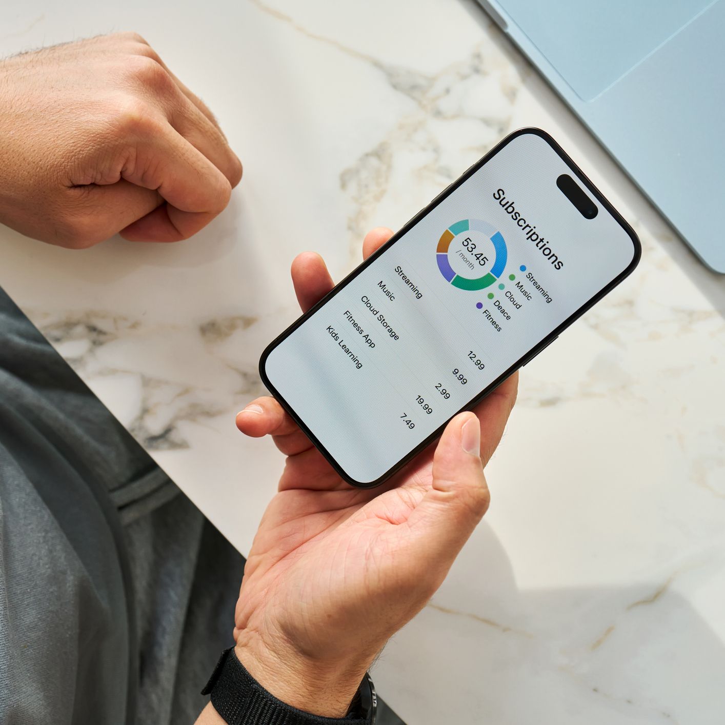 A woman reviews a list of all of her subscriptions on her phone.