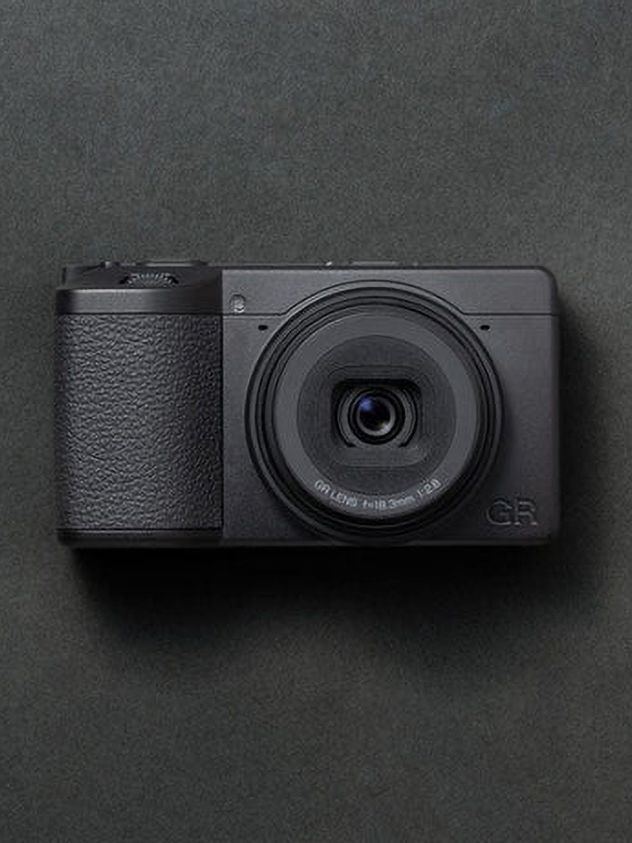 Ricoh GR IV Monochrome compact camera in a studio with gray backdrop