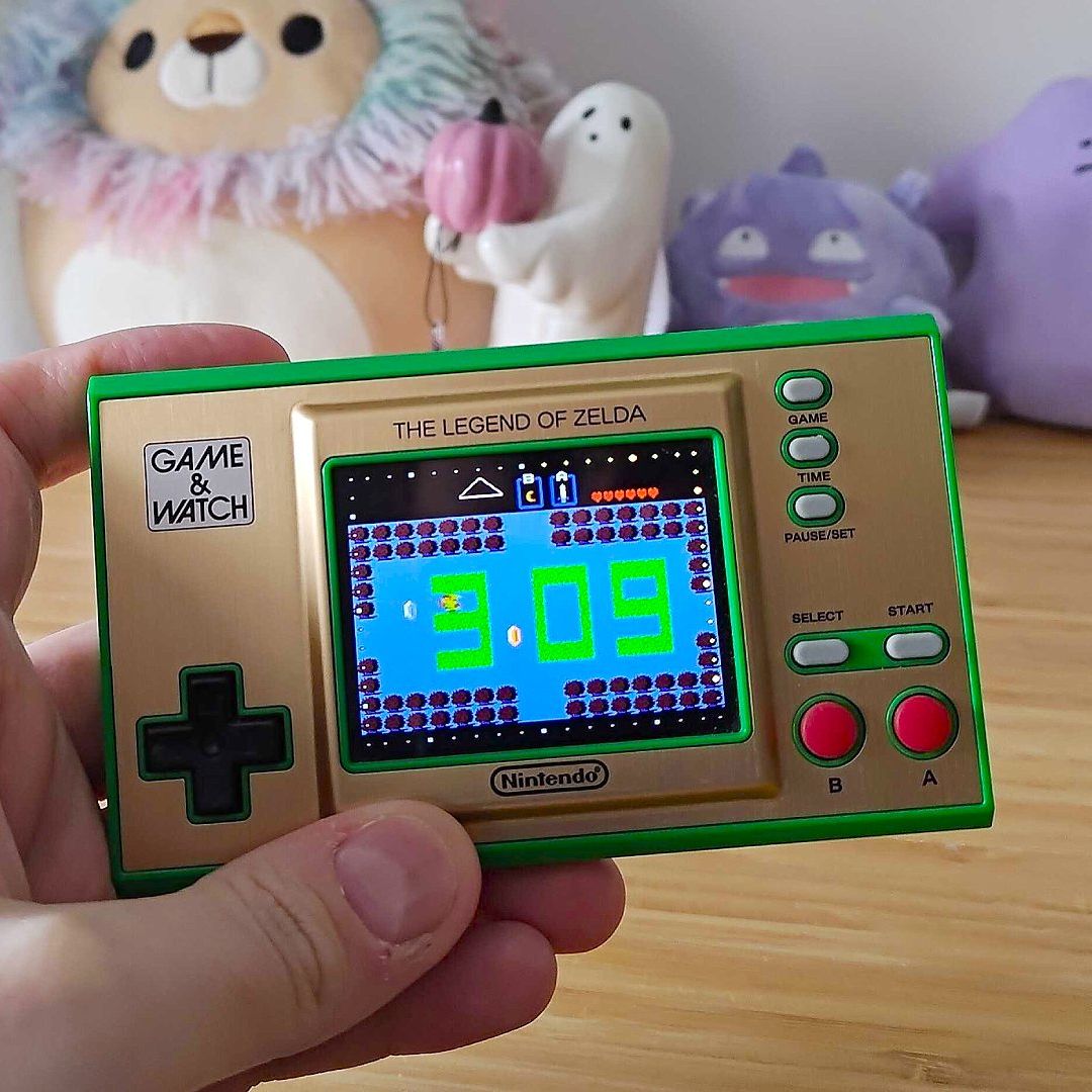Hand holding Zelda: Game and Watch with clock mode displayed