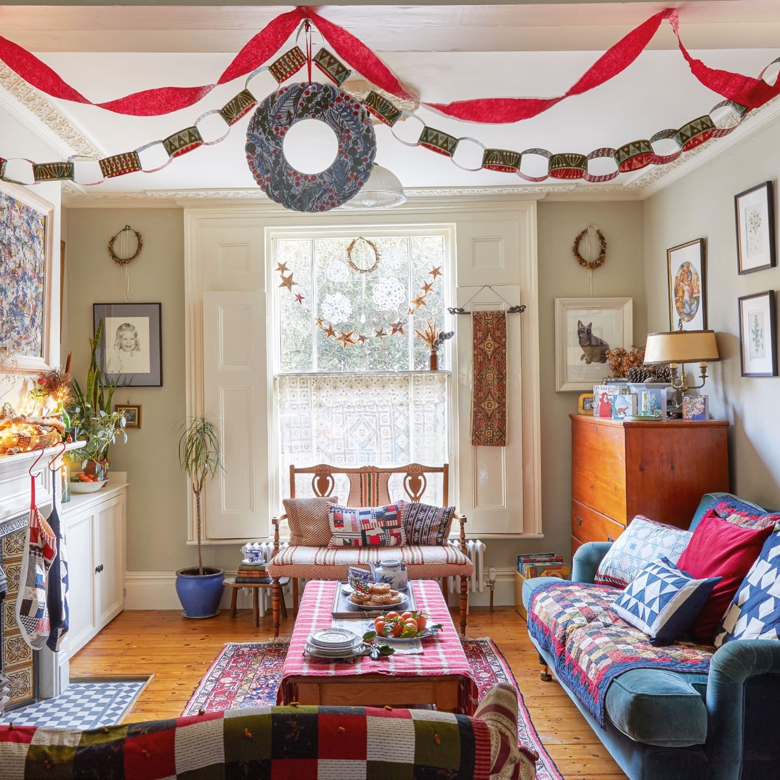 Living room with vintage furniture, patchwork throws and cushions, decorated for Christmas