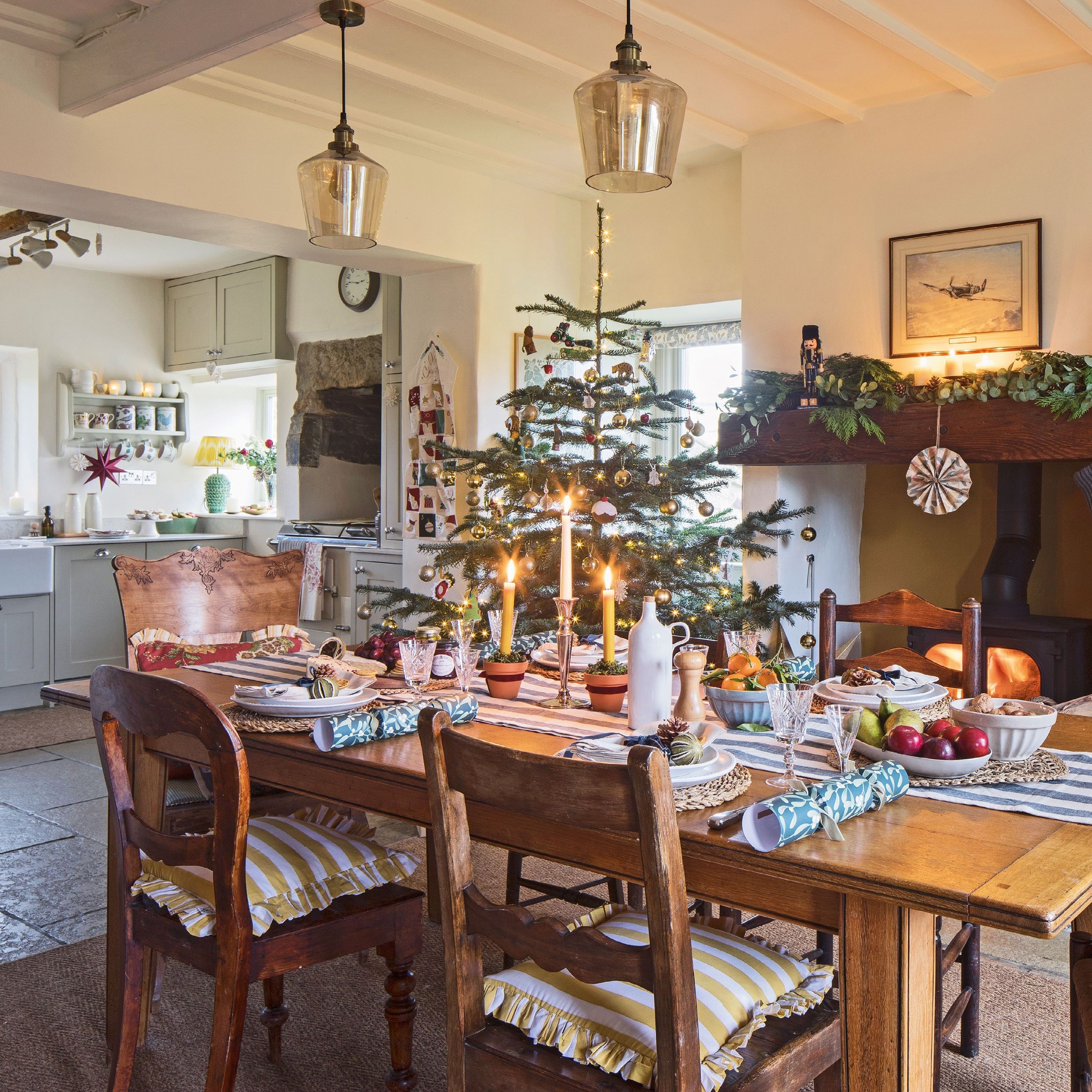 An open plan farmhouse dining room and kitchen with a wood burner, dressed for Christmas