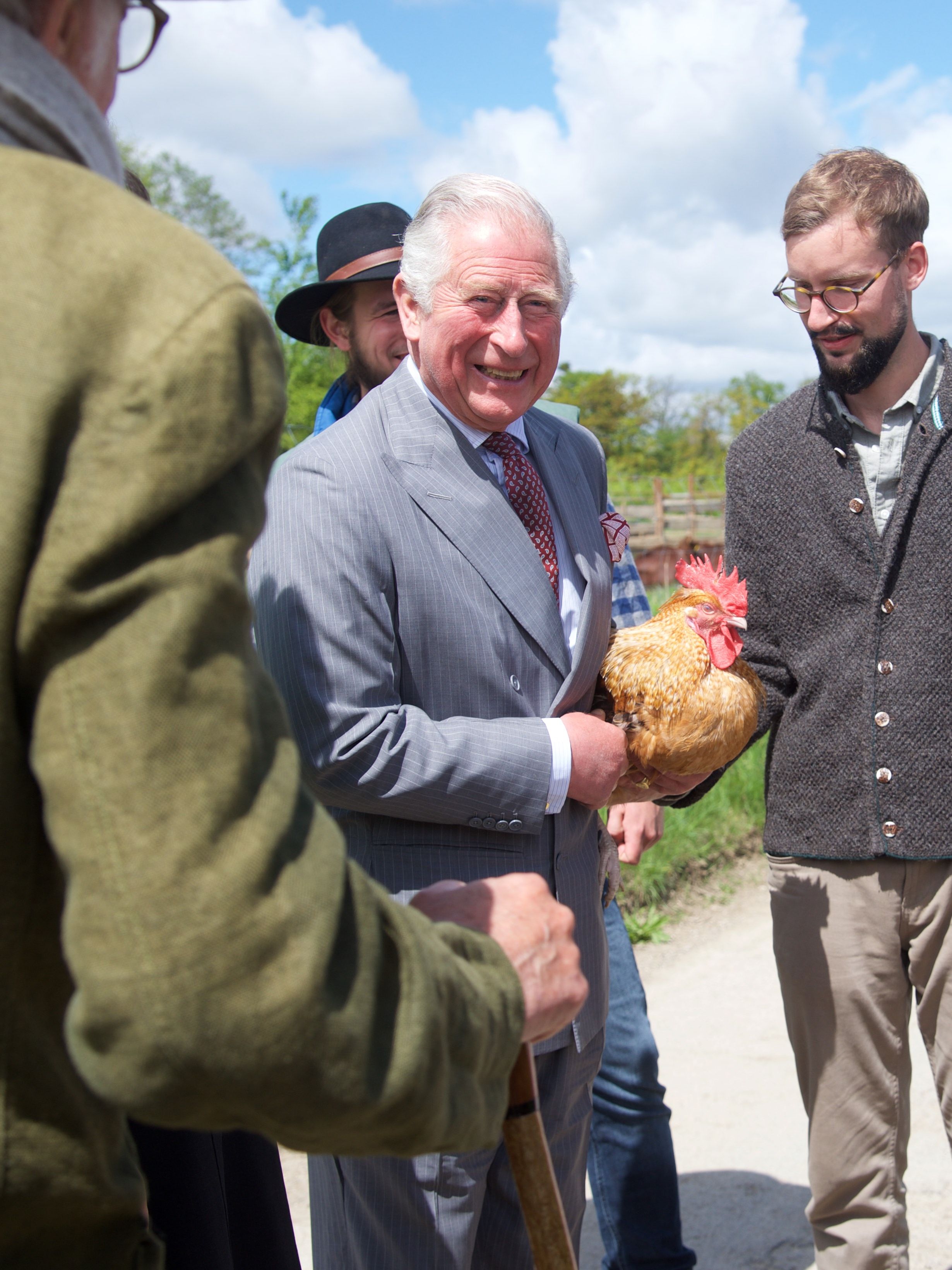 Prince Charles, Prince of Wales, holds a chicken alongside Sophie Schweinsfurth and Mathias Stinglwagner during a visit to the organic farm Herrmannsdorfer Landwerkstaetten on May 10, 2019 in Glonn near Munich, Germany. Their Royal Highnesses are paying an official visit to Germany at the request of the British government. The four-day-trip from May 7-10 will include visits to Berlin, Leipzig and Munich. (Photo by Pool/Getty Images)