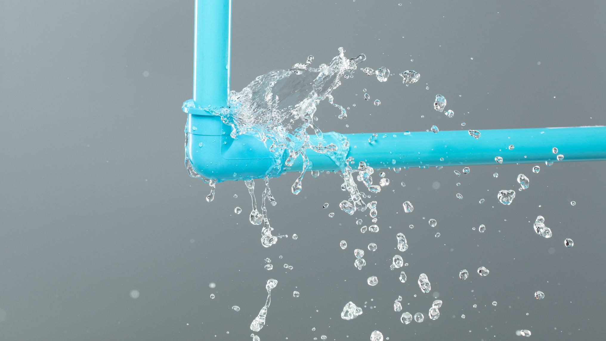Leaking water from blue pvc plastic pipe under sink.