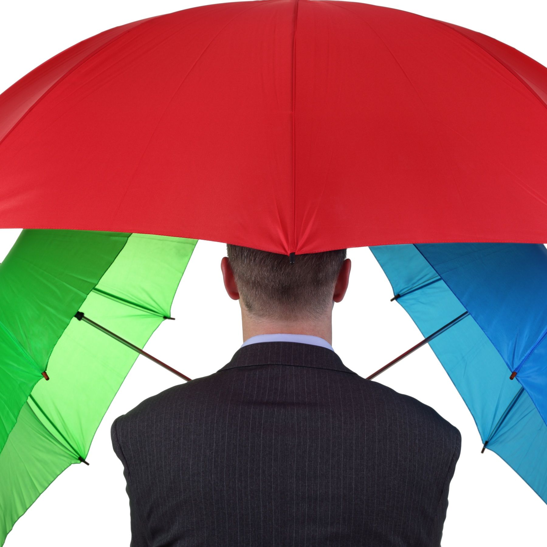 A man holds three umbrellas, his back to the camera.