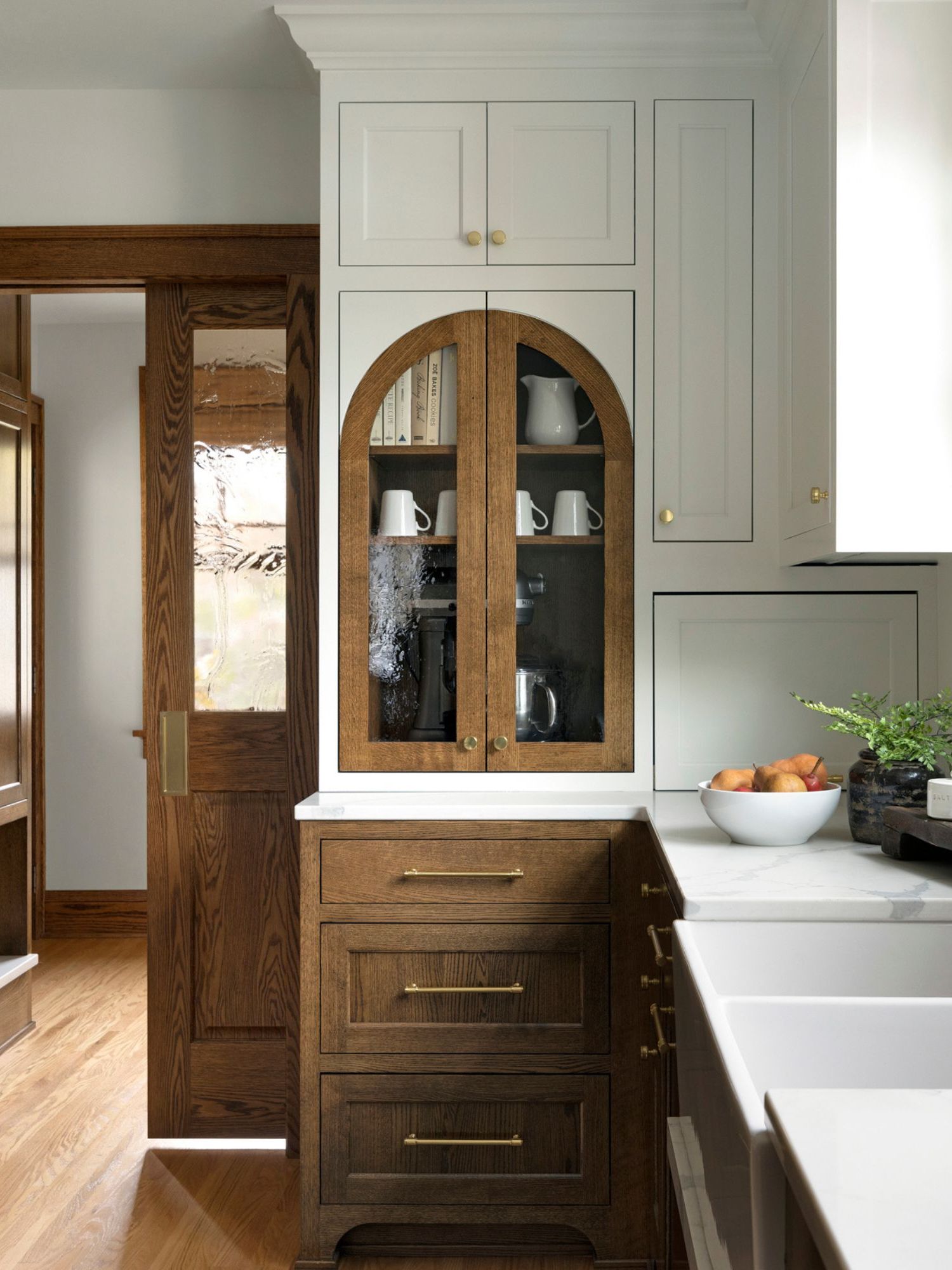 A small kitchen with wooden cabinets and an integrated fridge