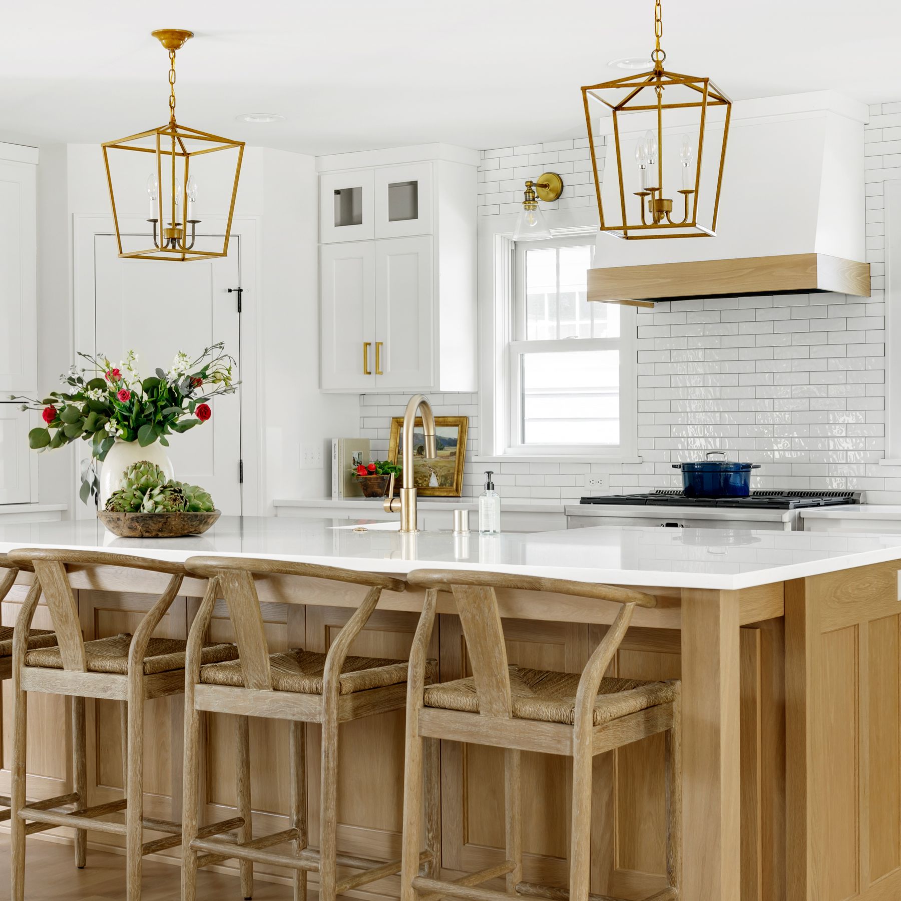 A modern kitchen peninsula with waterfall countertop and stylish bar stools, demonstrating that are kitchen peninsulas outdated is a myth.