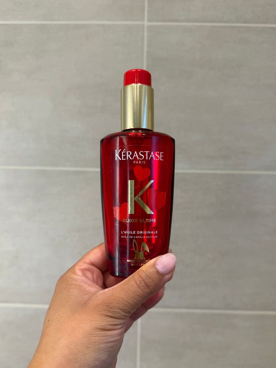 Aleesha holding empty kerastase elixir ultime oil