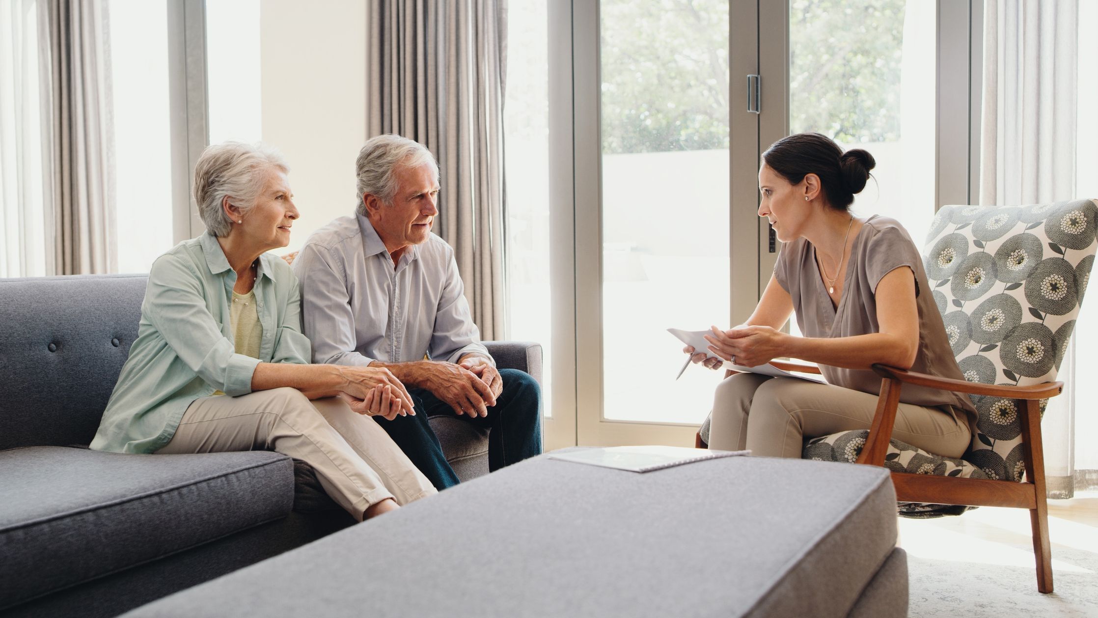 Retirement, finance and planning for the future with a senior couple and a female broker in the living room at home.