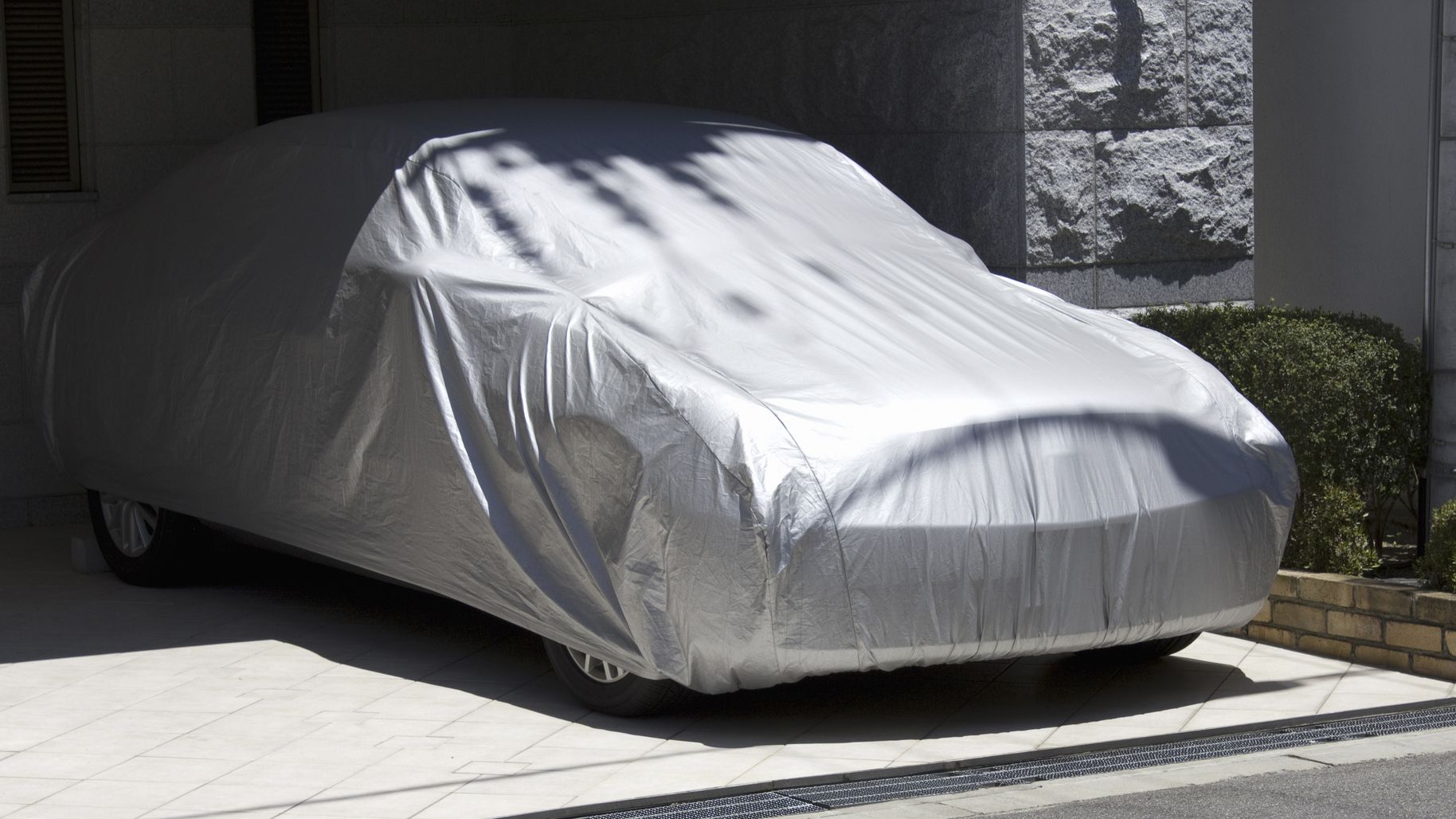A car completely covered with a protective cover.