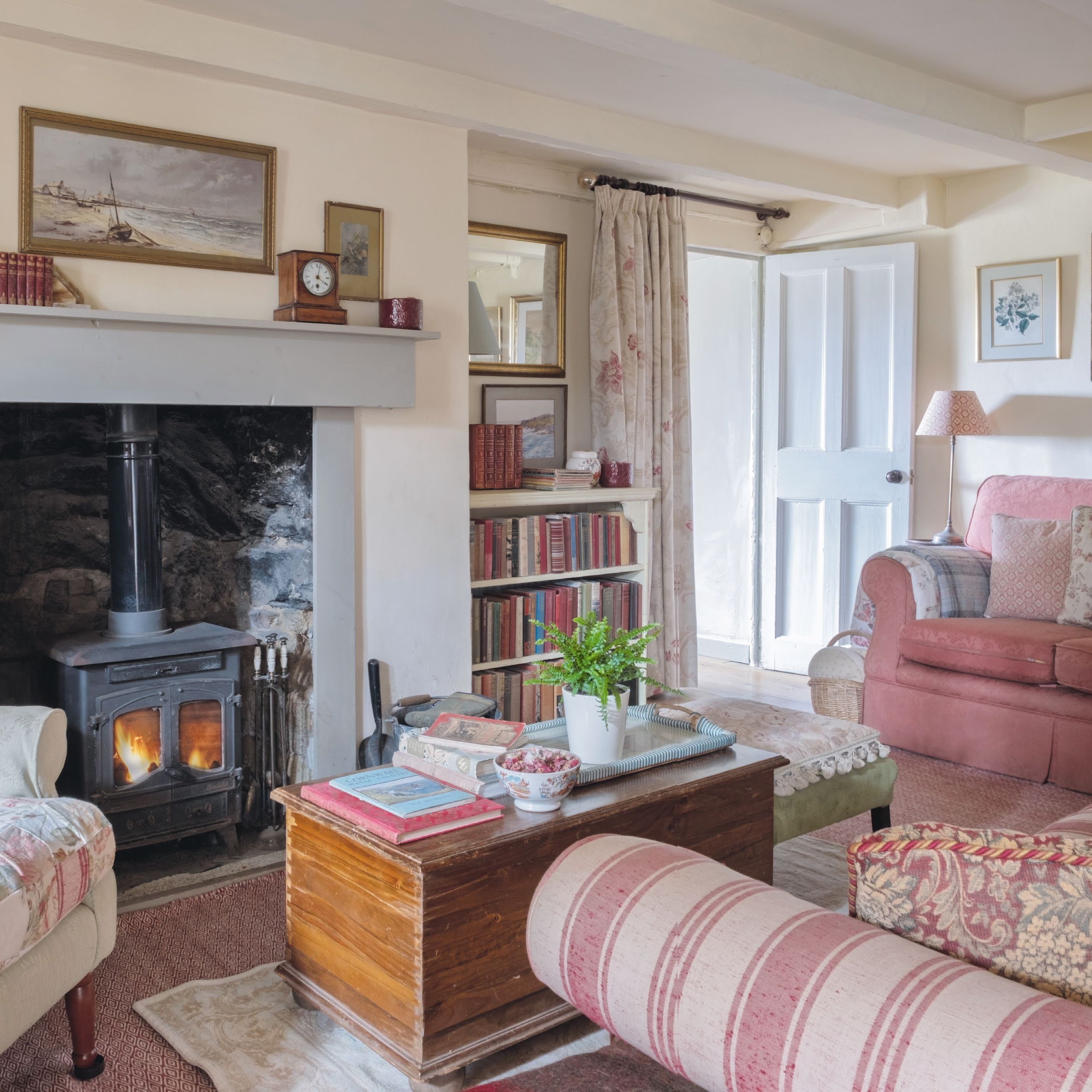 Cosy country cottage living room with wood burner, mixed comfy sofas and chairs and vintage furnishings