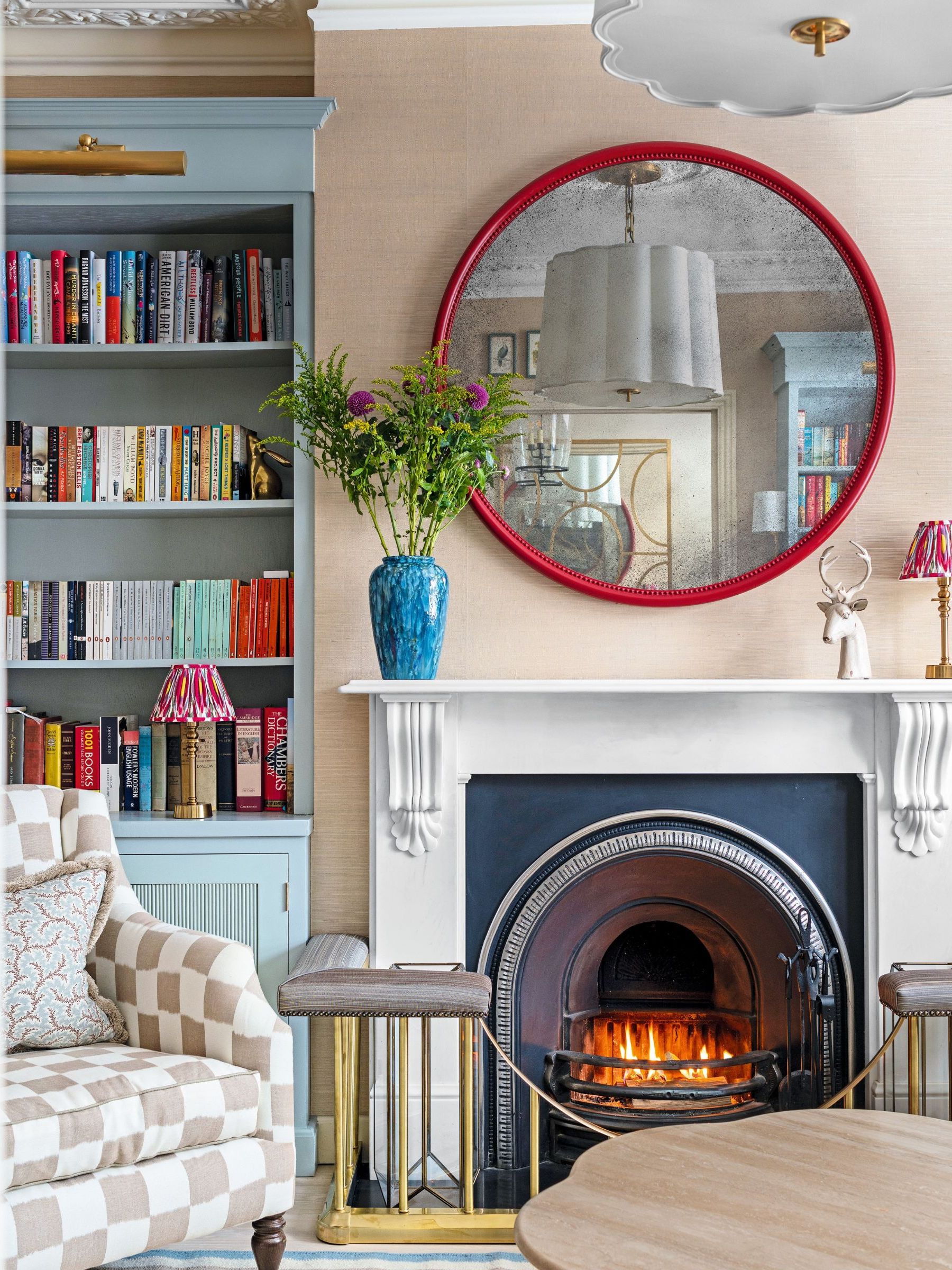 Blue bookshelf, red framed mirror, blue vase