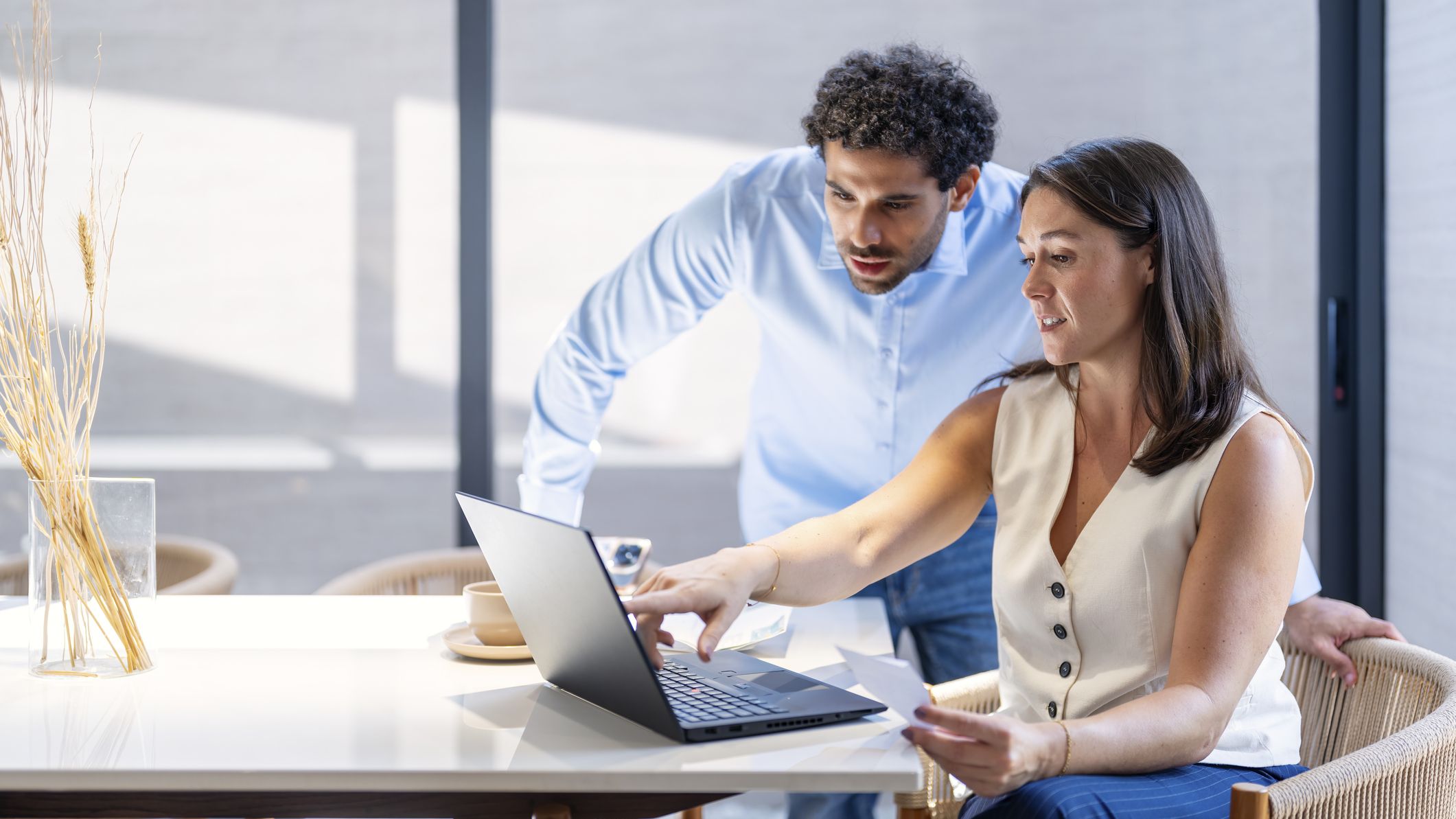 A man and woman reviewing a financial statement and doing accounting with a laptop computer.