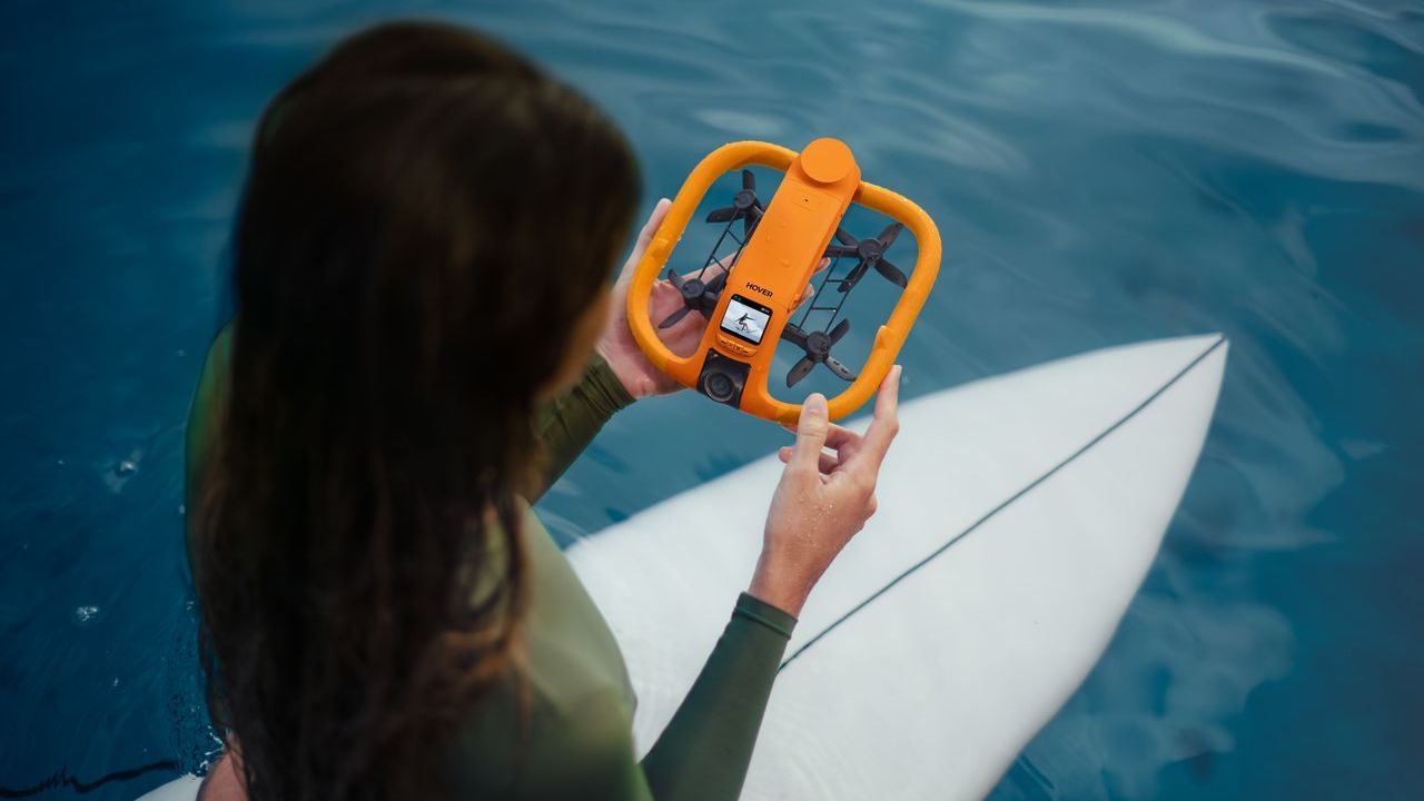 Person using HoverAir Aqua drone on paddle board