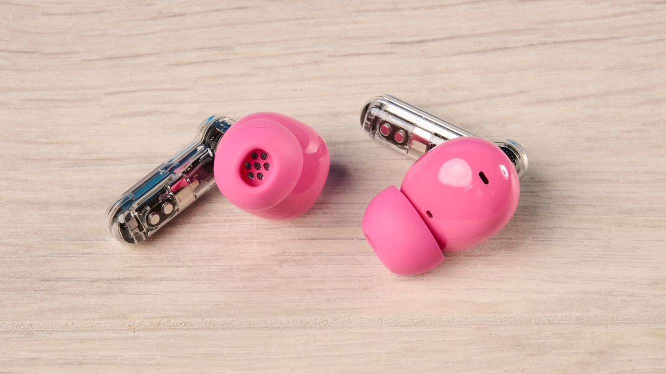 The Nothing Earbuds (3a) in pink, on a wooden surface
