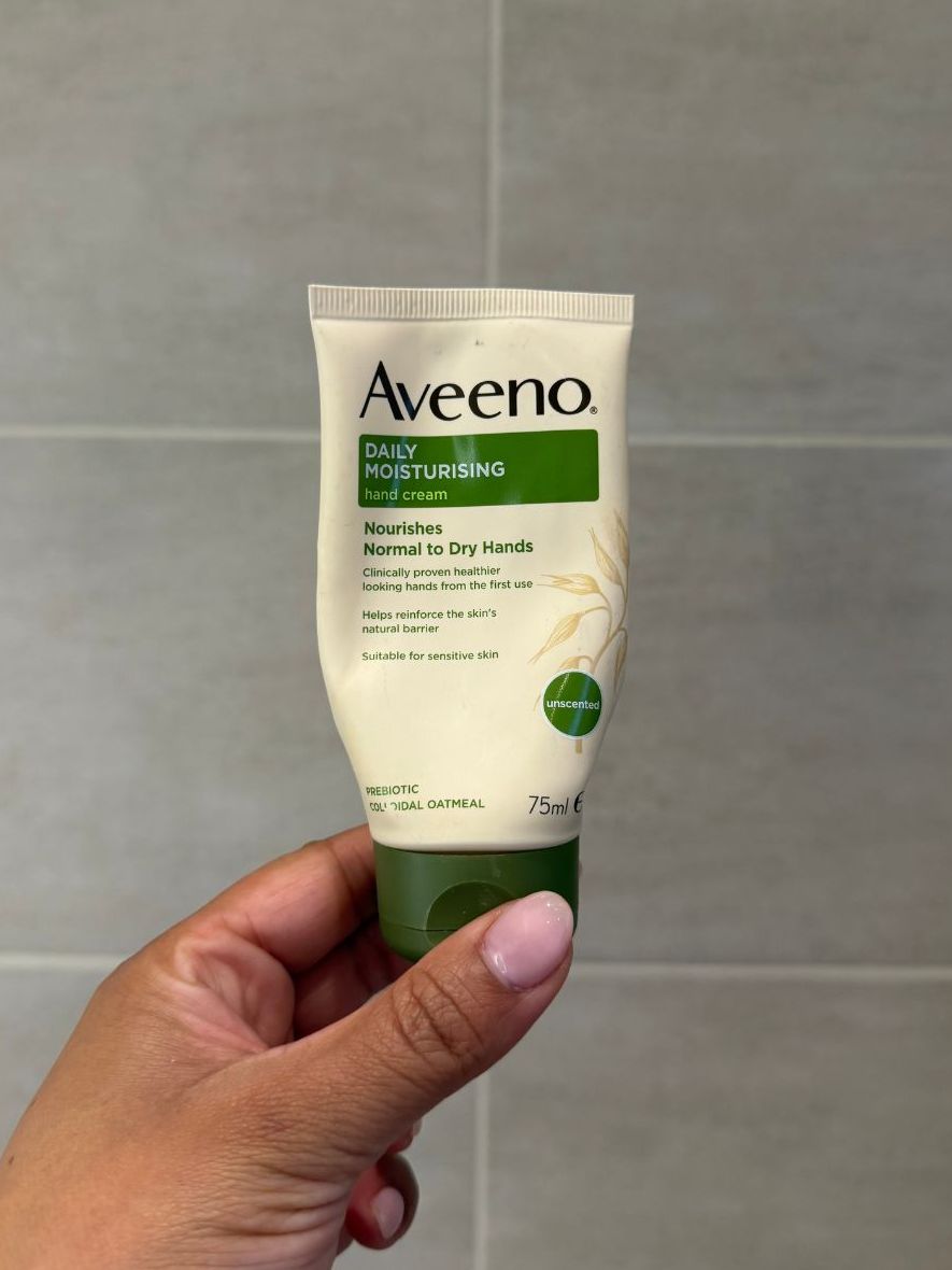 Aleesha holding empty Aveeno hand cream