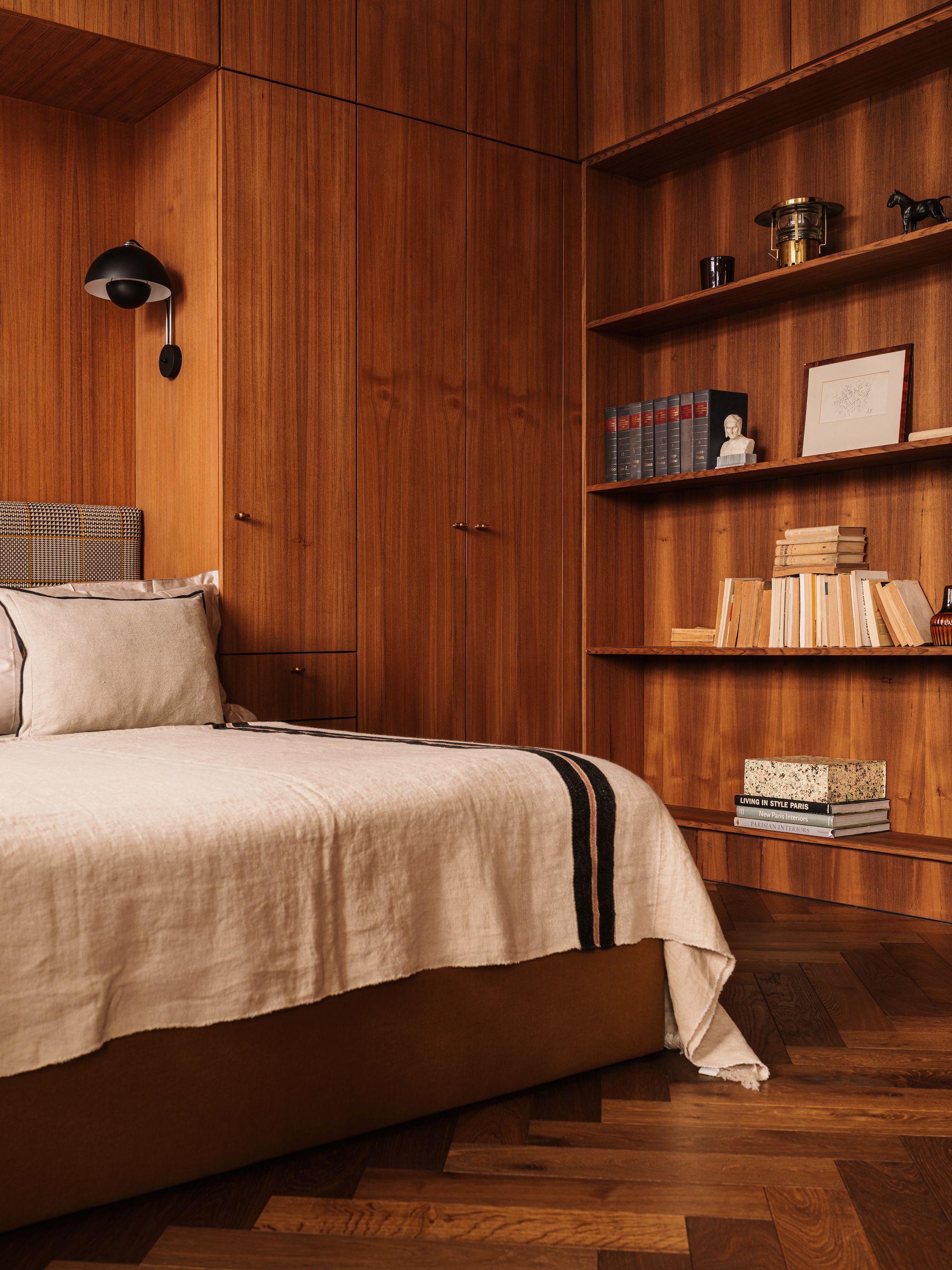 Wood-walled bedroom with linen bedspread