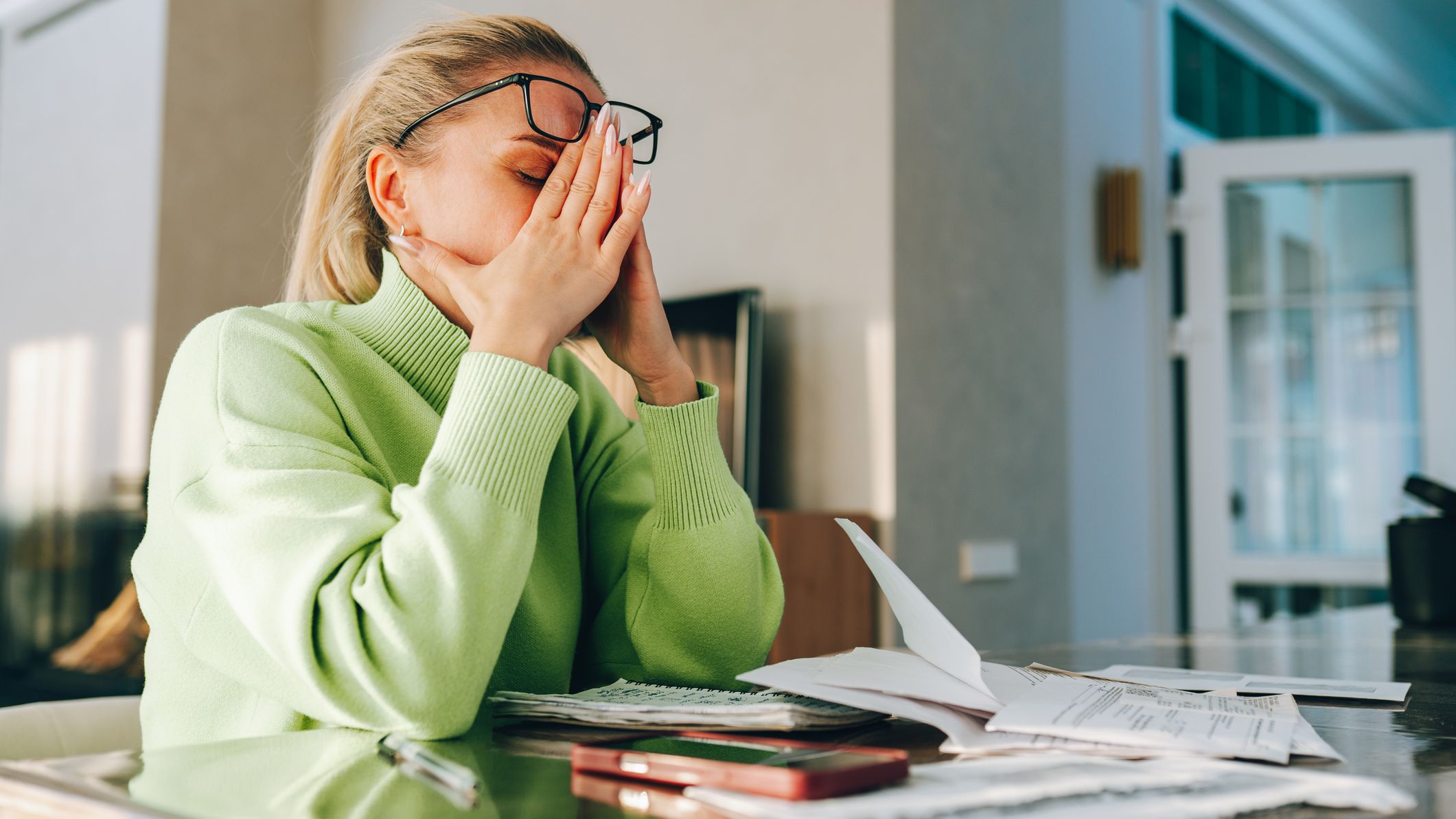 Stressed woman holding head feeling overwhelmed by bills