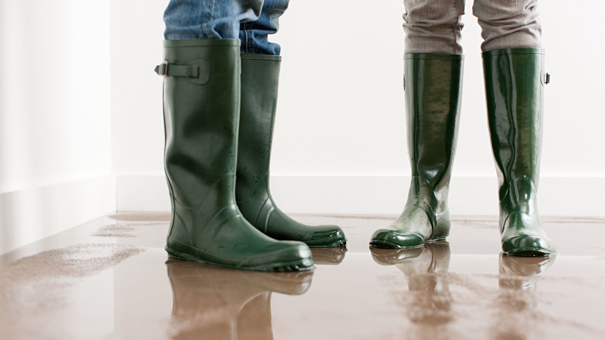 Young couple in wellington boots on flooded floor.