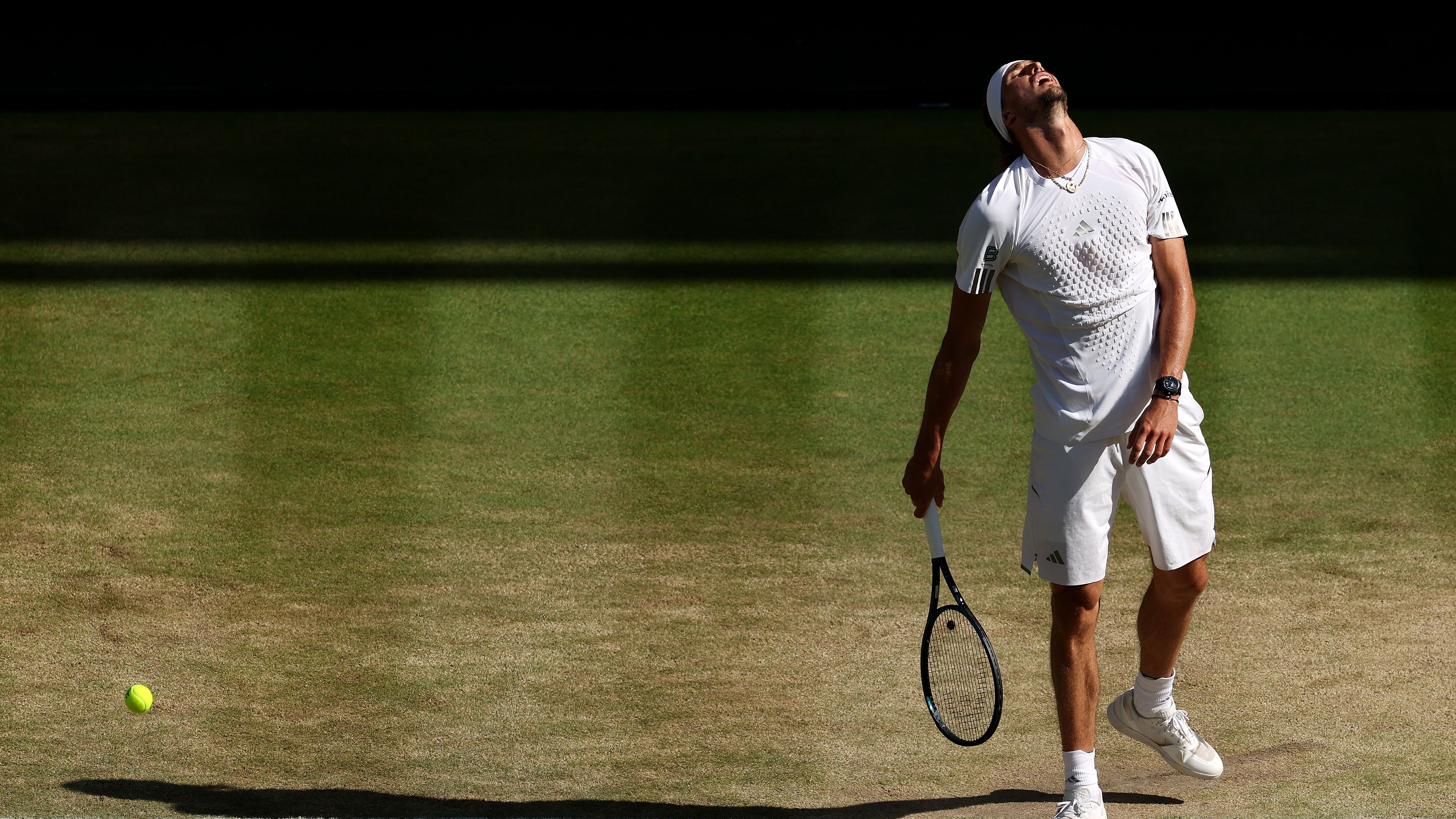 Alexander Zverev looks up with disappointment, racquet in hand, as a tennis ball passes by to his left