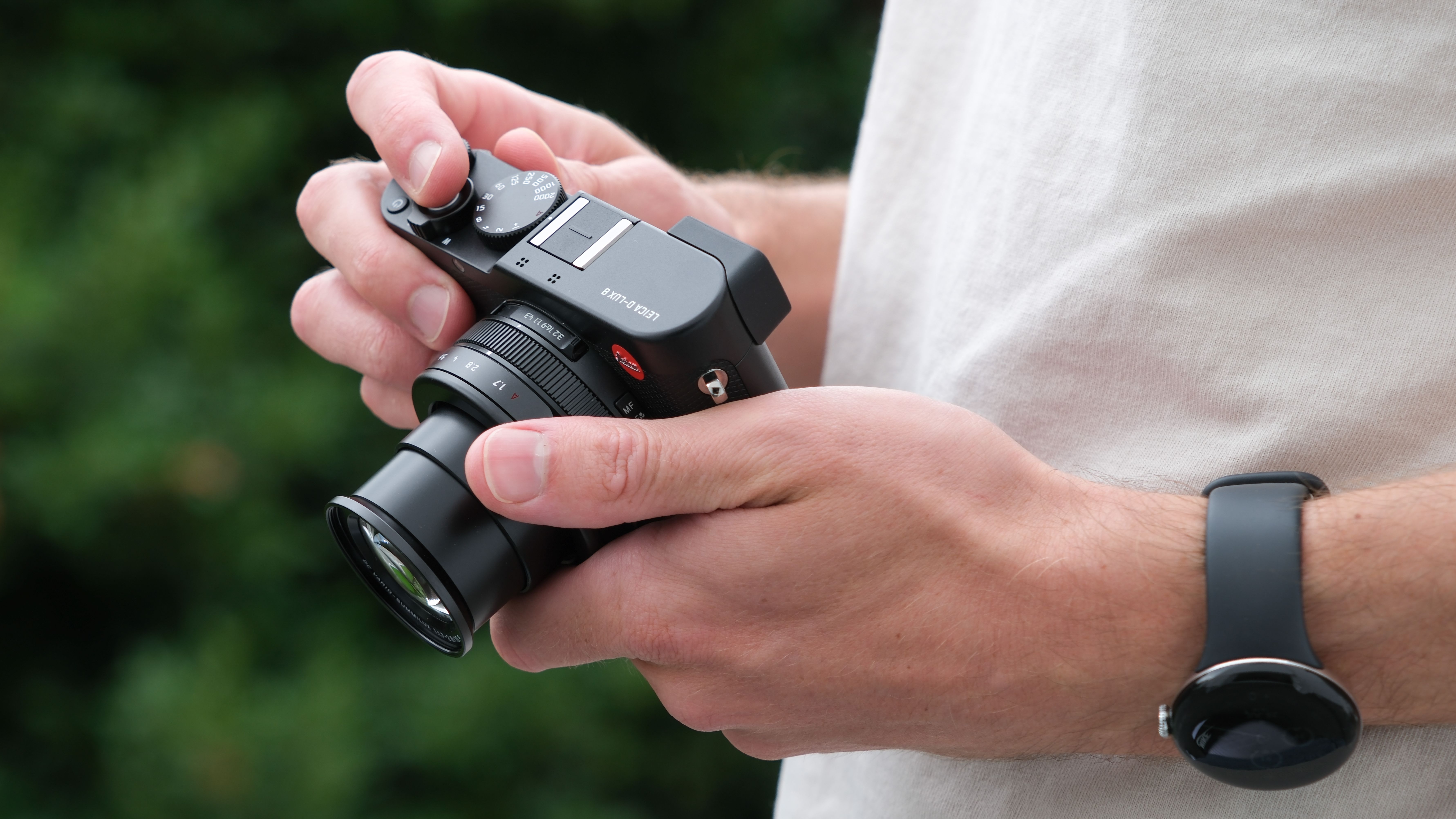 Leica D-Lux 8 camera held in a pair of hands