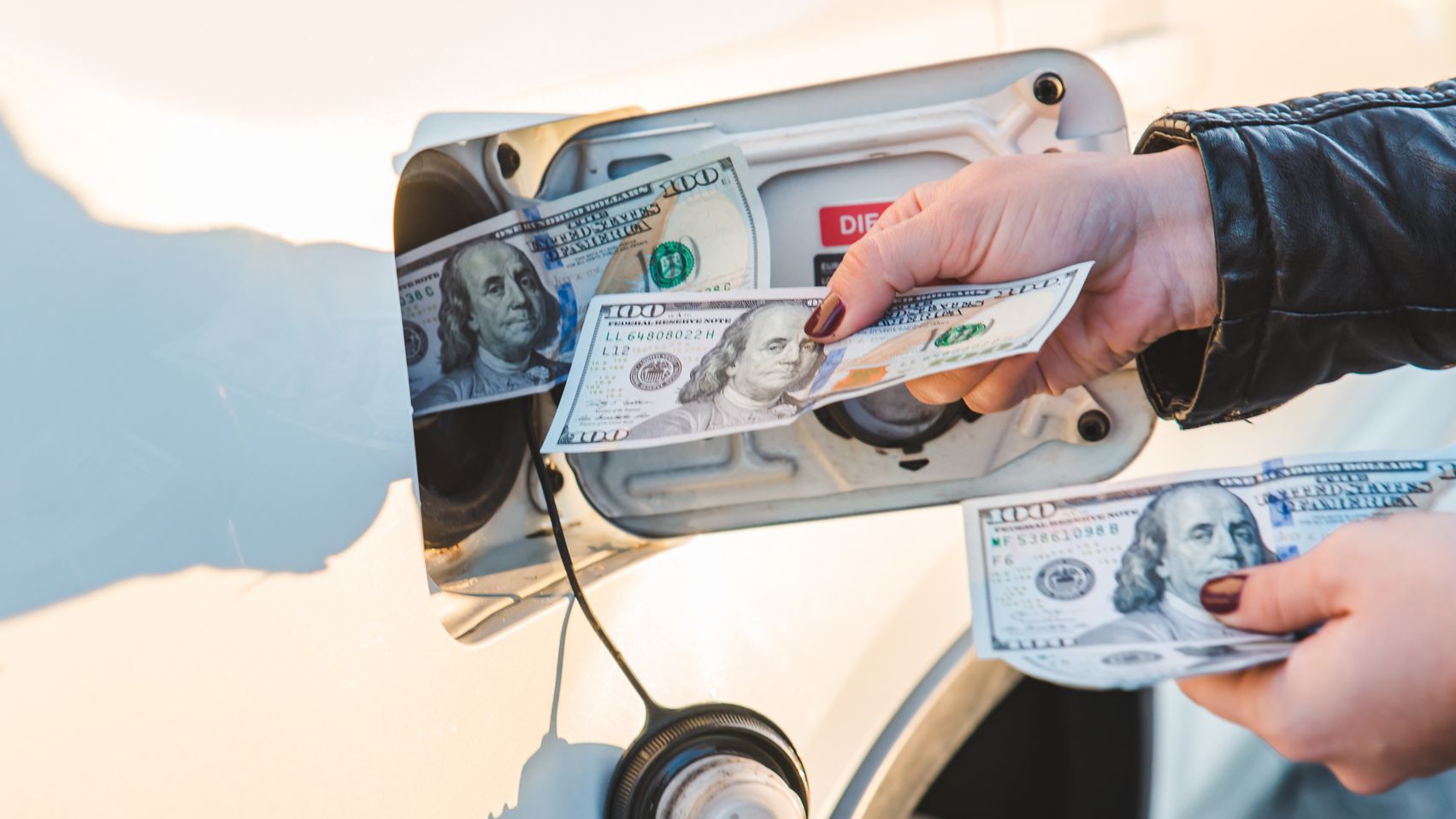 Woman put money to car tank.