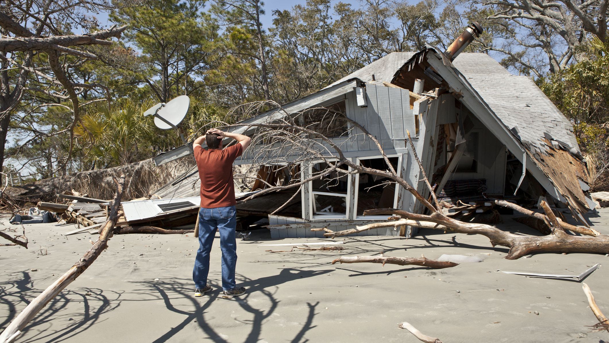 Man grieving over destroyed house
