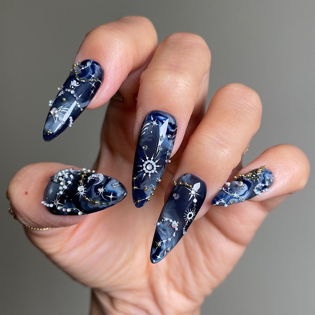 blue manicure with dark celestial details