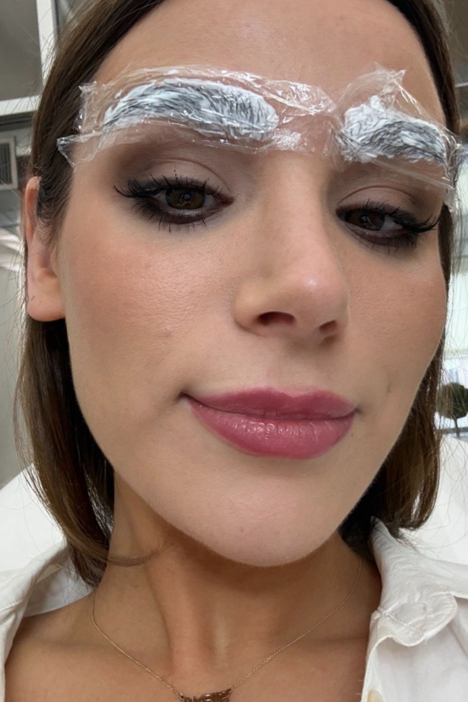 a girl getting her eyebrows numbed before nanobrows