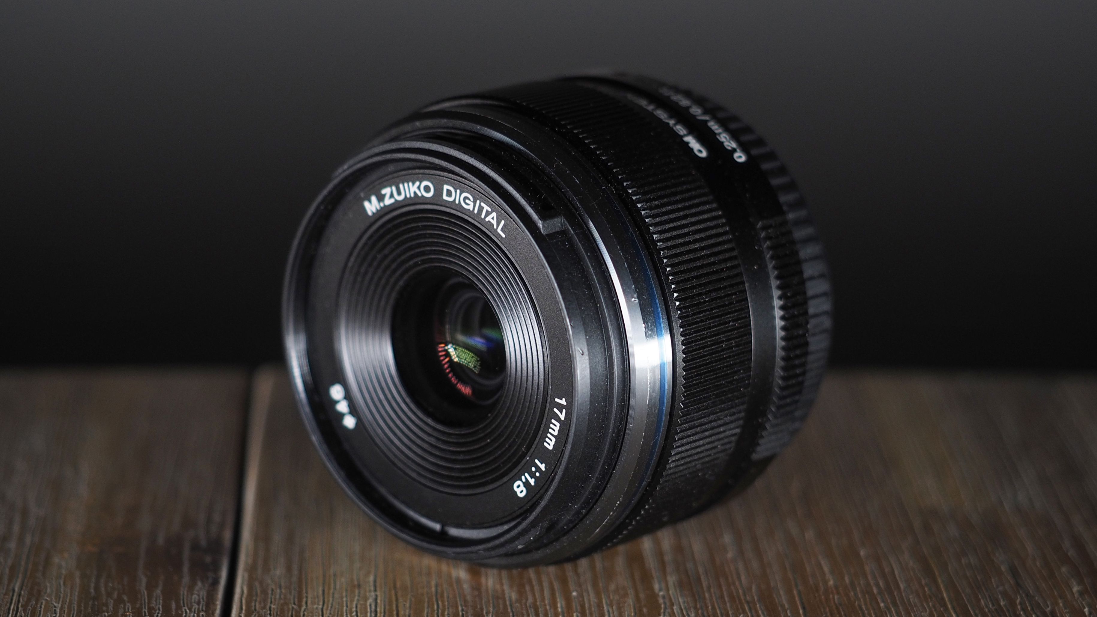 OM System M.Zuiko 17mm f/1.8 II lens on a wooden surface
