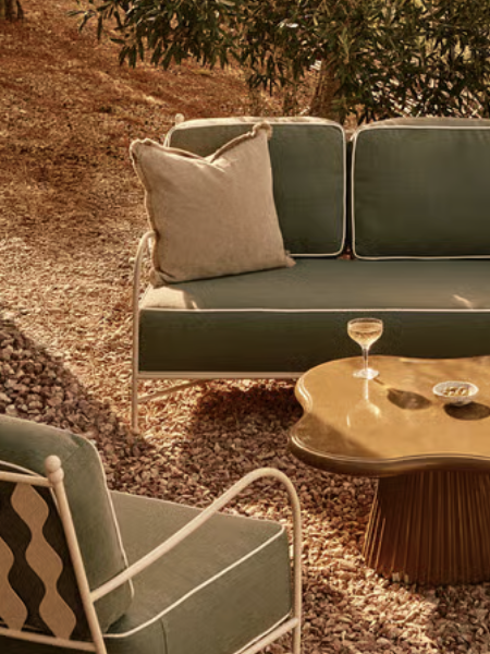 white metal outdoor sofa and chairs with deep green cushions