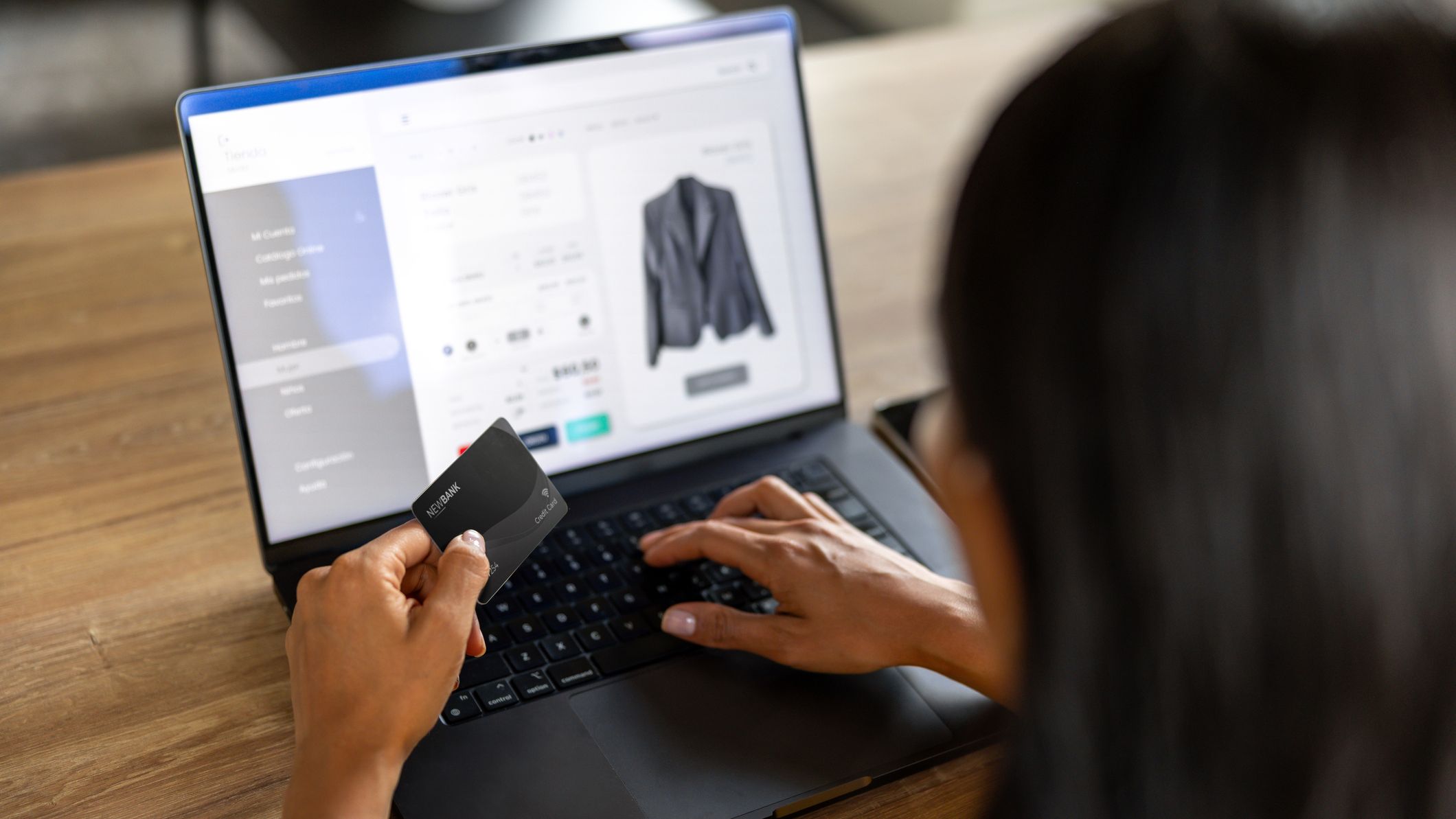 A woman online shopping with credit card in hand