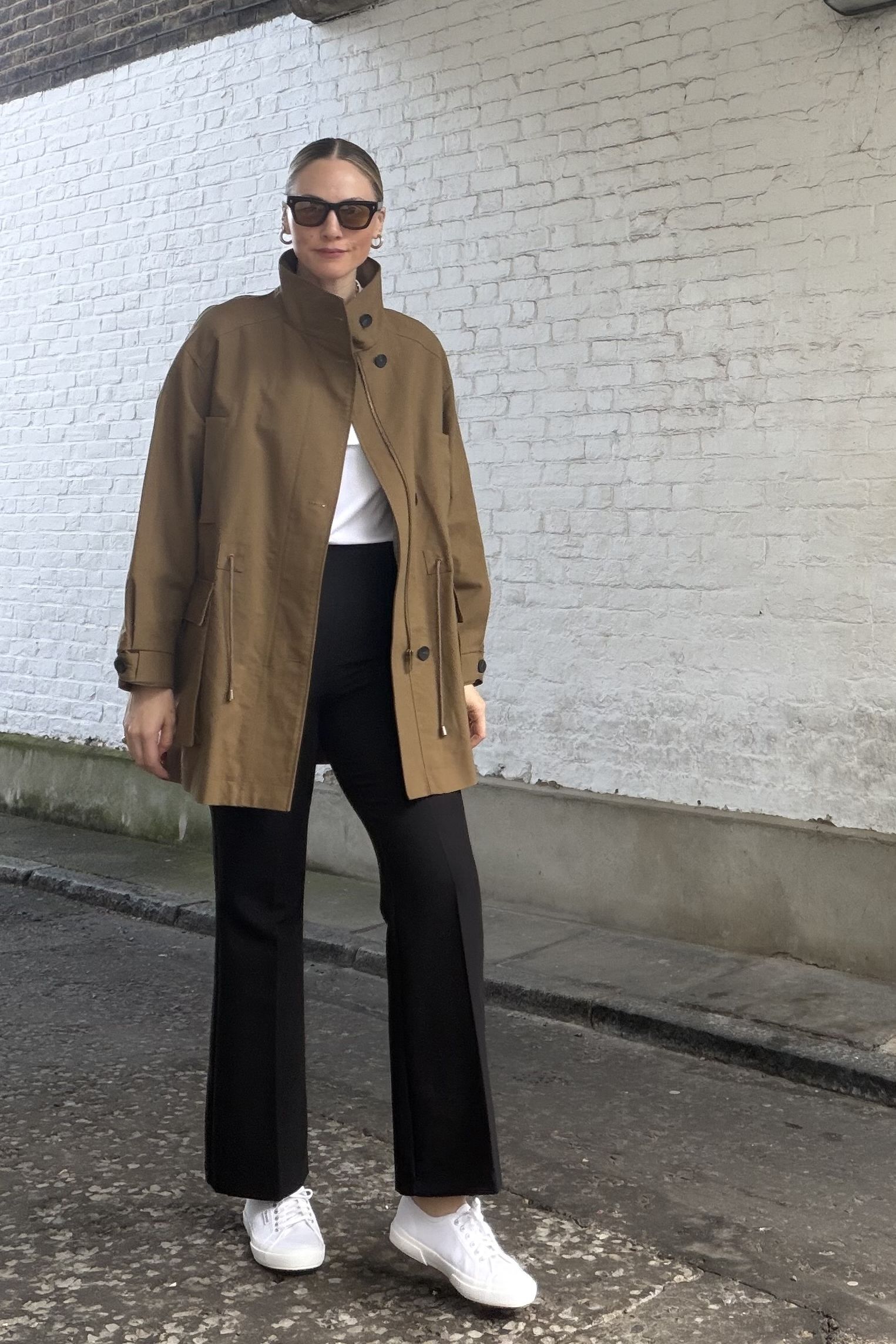 Brooke Ely Danielson wears white Supergas with a funnel neck parka and black pants