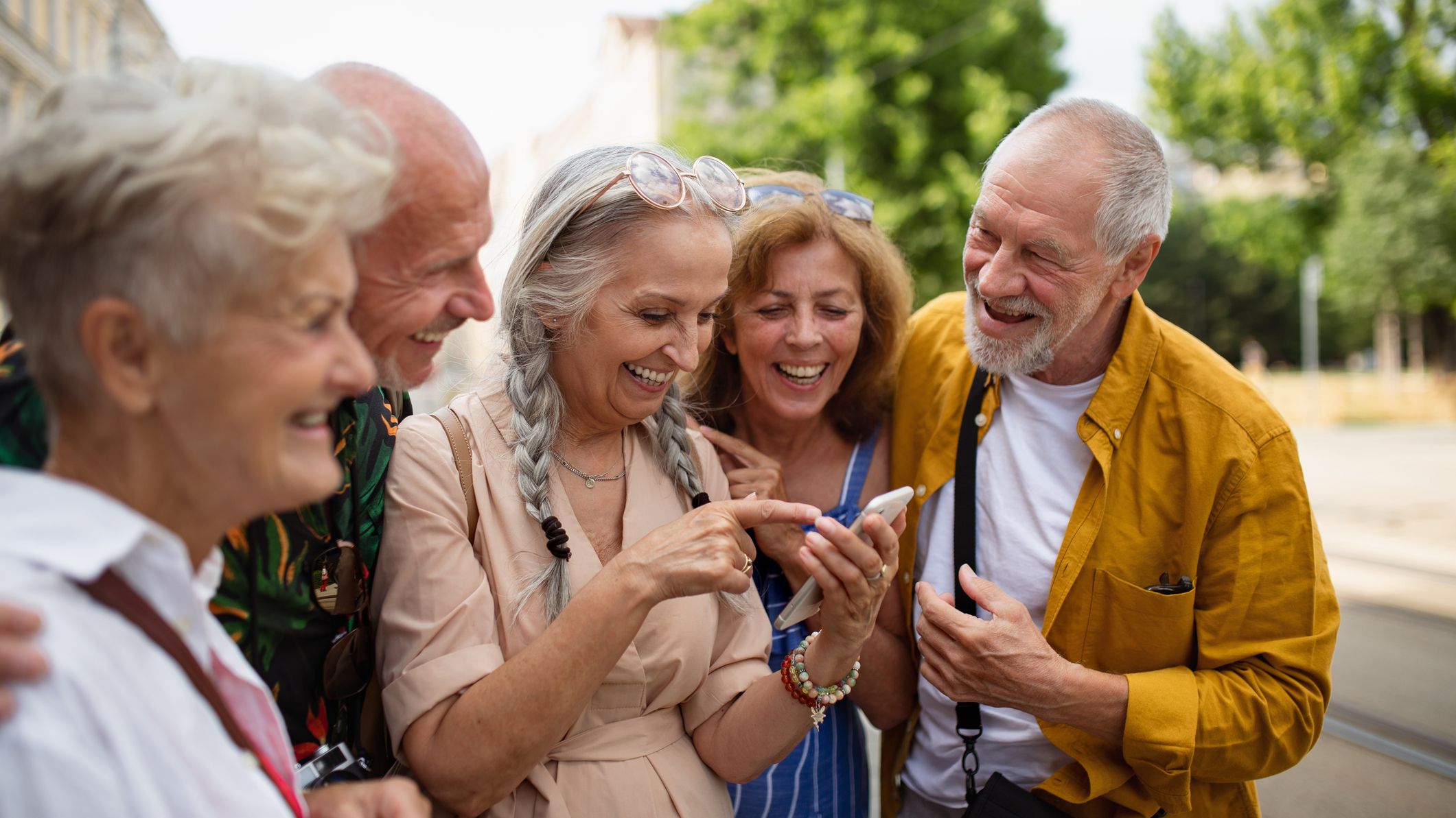 Cheerful men and women travelers looking for direction.
