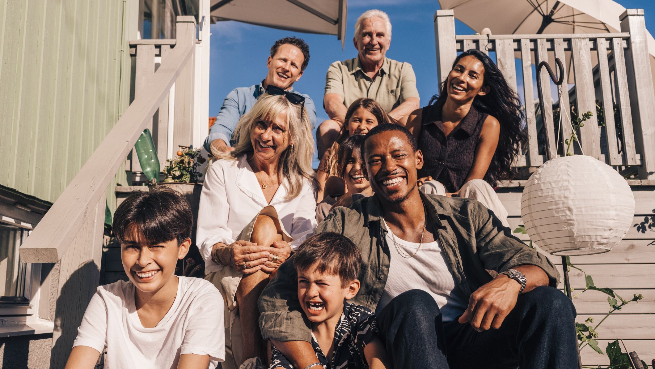 Family sitting on the steps of a beach house.