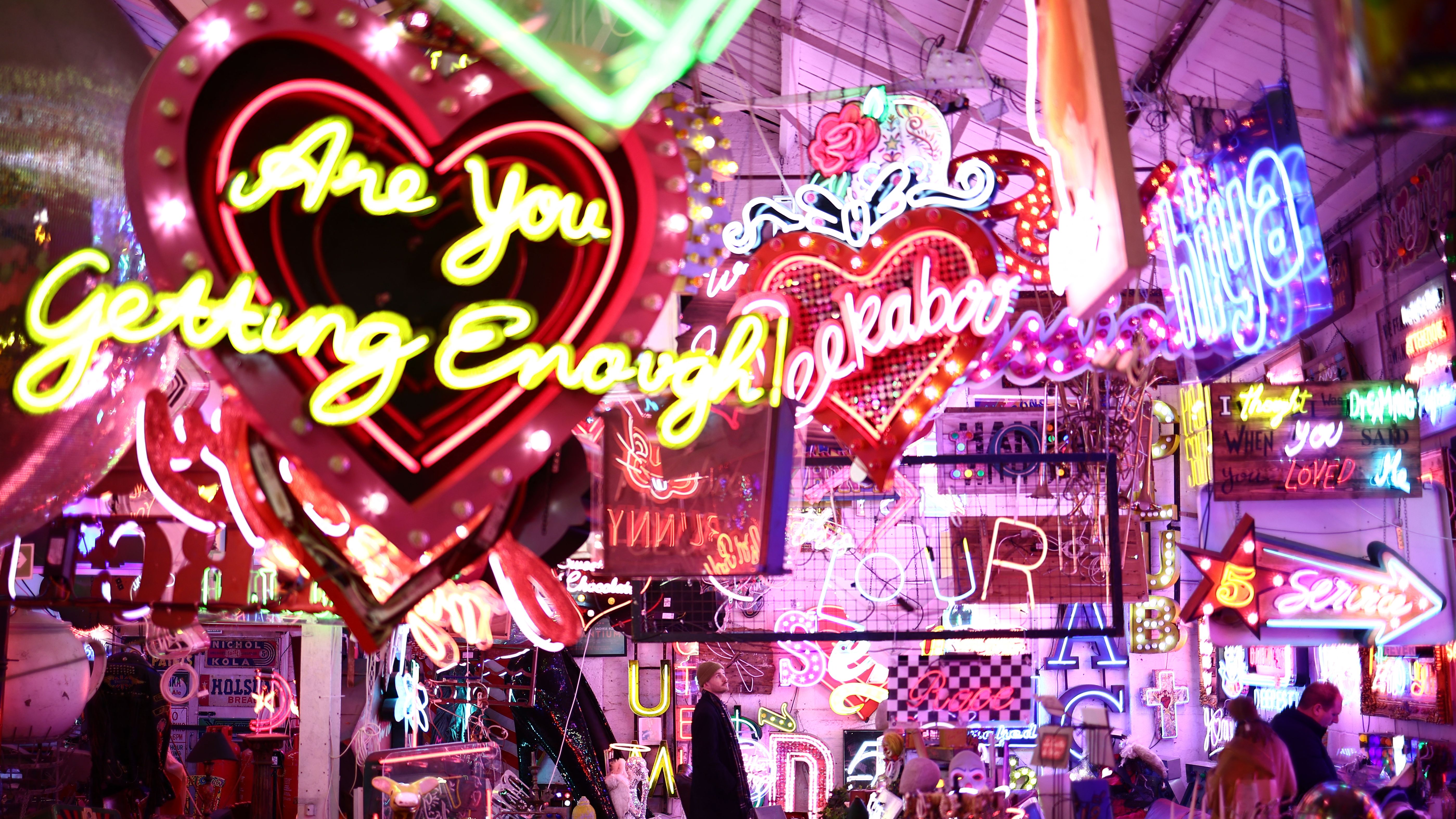 Members of the public explore inside &amp;quot;God's Own Junkyard&amp;quot;, a warehouse of neon artworks and signage in east london on January 17, 2025. From neon signs in the Soho district of London to the backdrop of Kubrick's Eyes Wide Shut and Ridley Scott's Bladerunner, the Bracey family's influence on modern culture is showcased in a huge warehouse in Walthamstaw, where visitors can peruse pieces of movie memorabilia or purchase their own neon showpiece. (Photo by HENRY NICHOLLS / AFP)