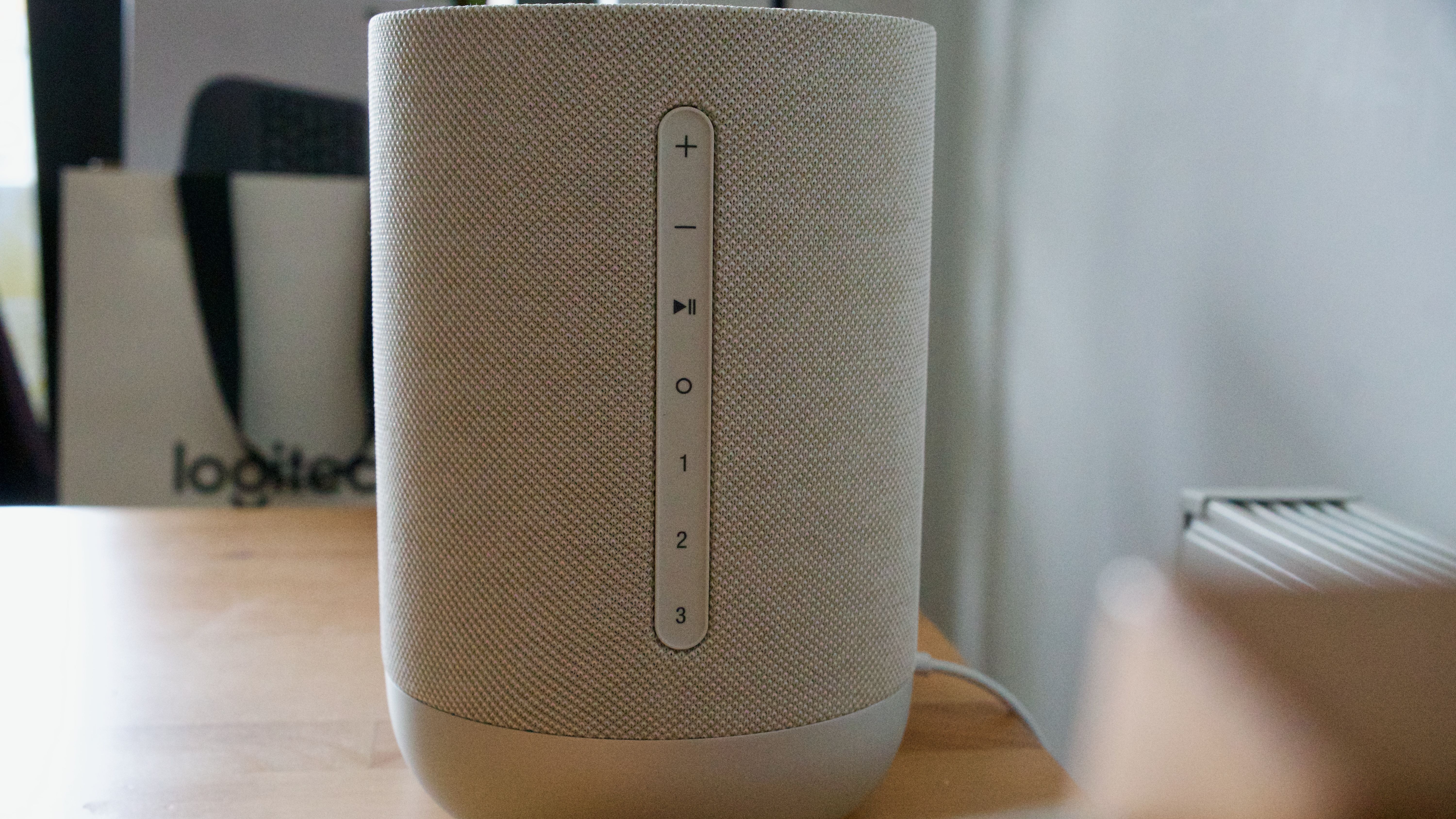 Rear panel of the Denon Home 400 home speaker, showing buttons and preset options, on a wooden surface