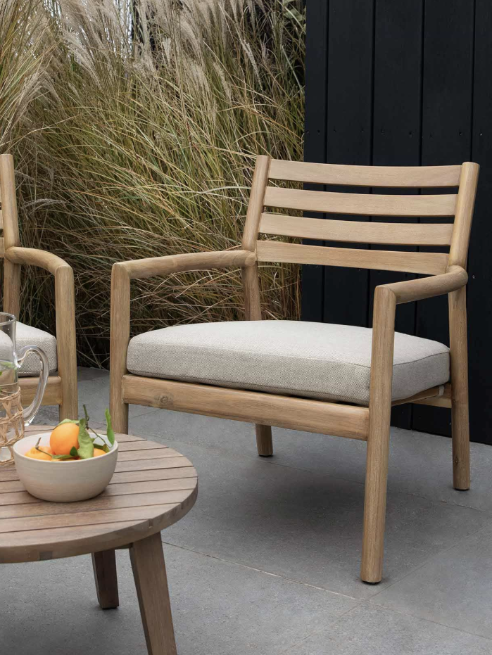 two wooden chairs and side table on a patio