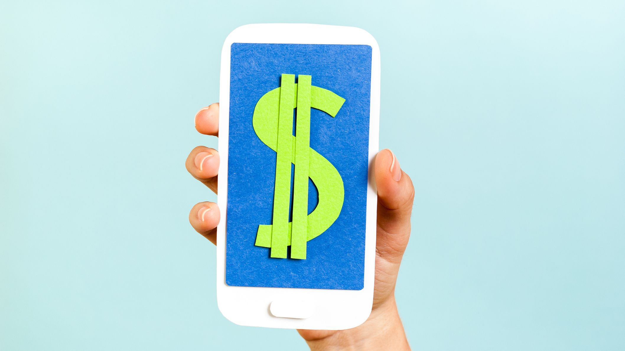 a hand holds up a cell phone with a dollar sign on the screen