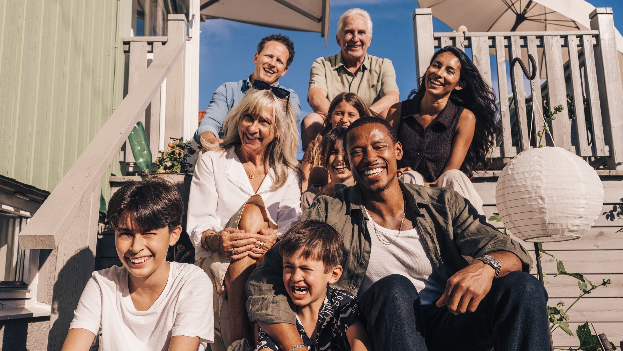Family sitting on the steps of a beach house.