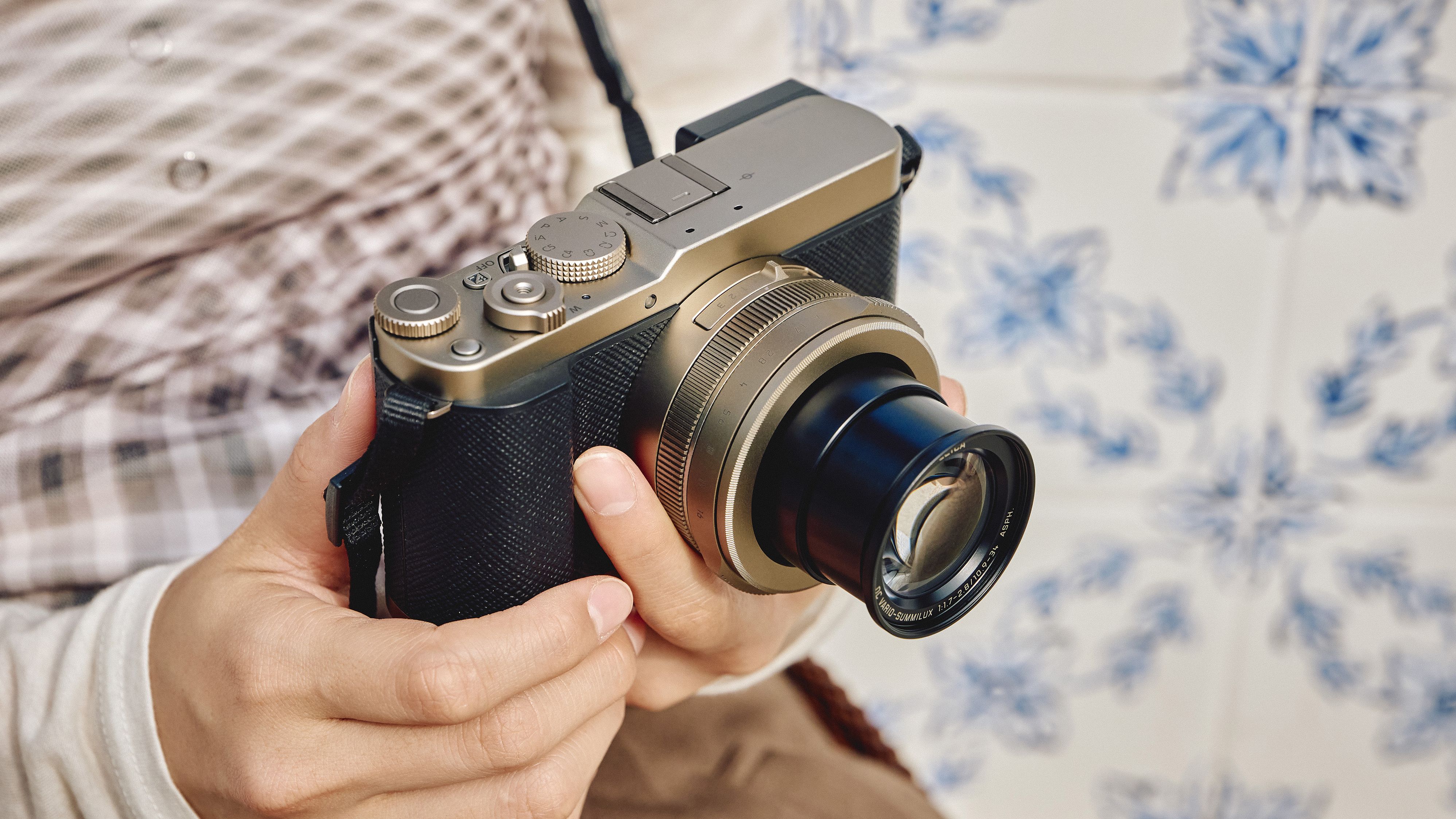 Panasonic Lumix L10 camera in gold held in a pair of hands