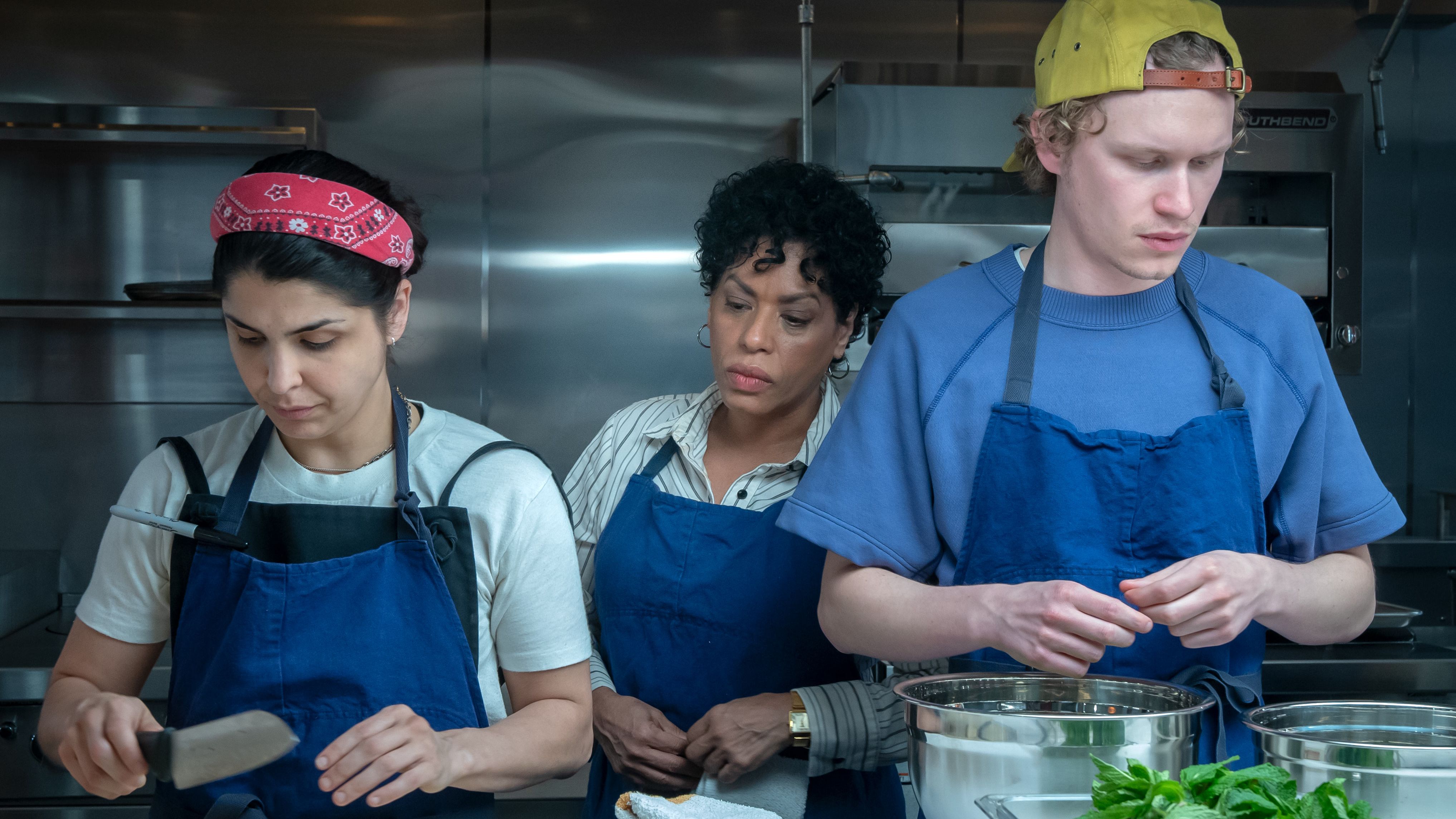 an image from The Bear season 2 showing Tina at culinary school with two classmates preparing food